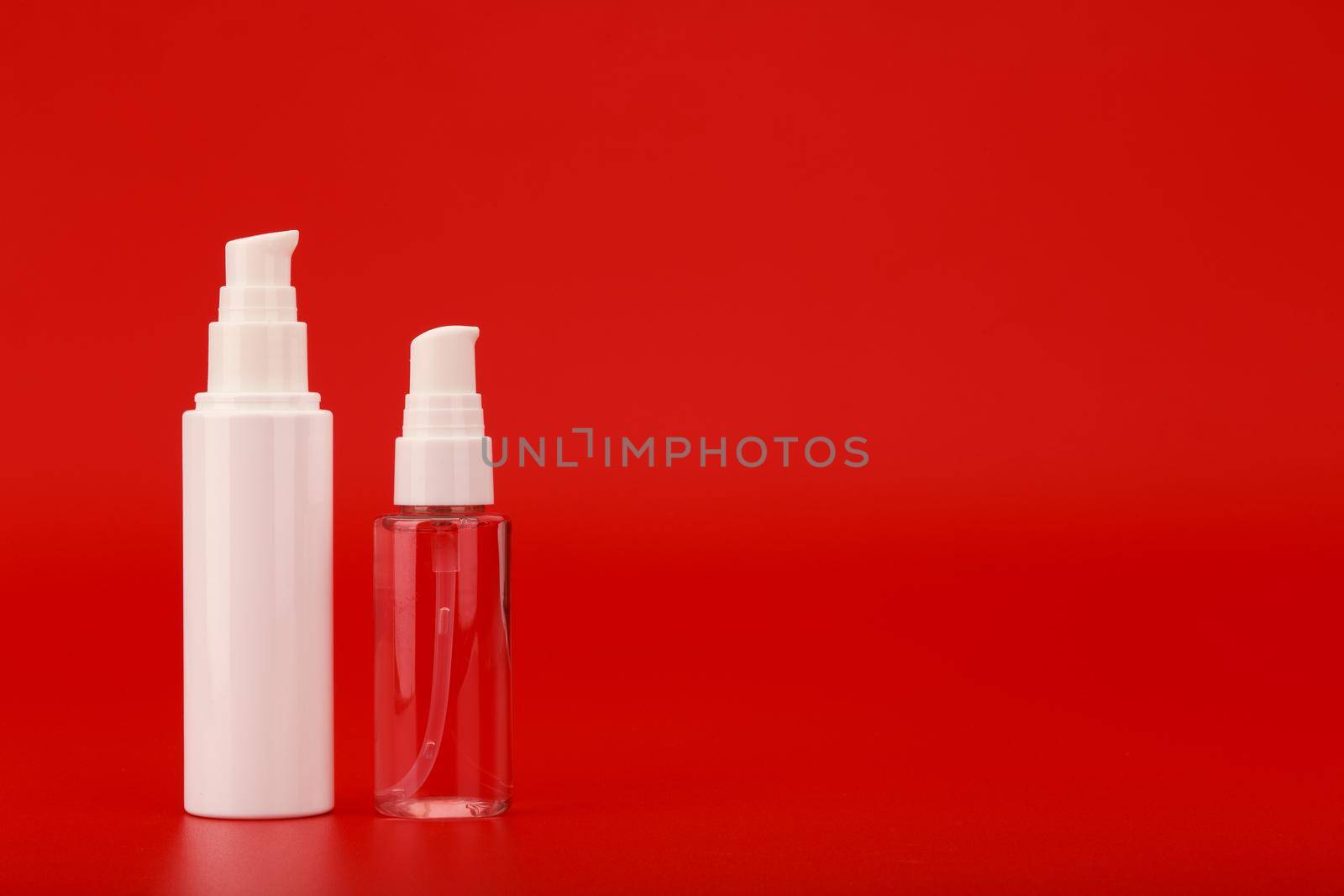 Face cream or lotion and cleansing gel fir washing against red empty background with copy space. Concept of skin care by Senorina_Irina