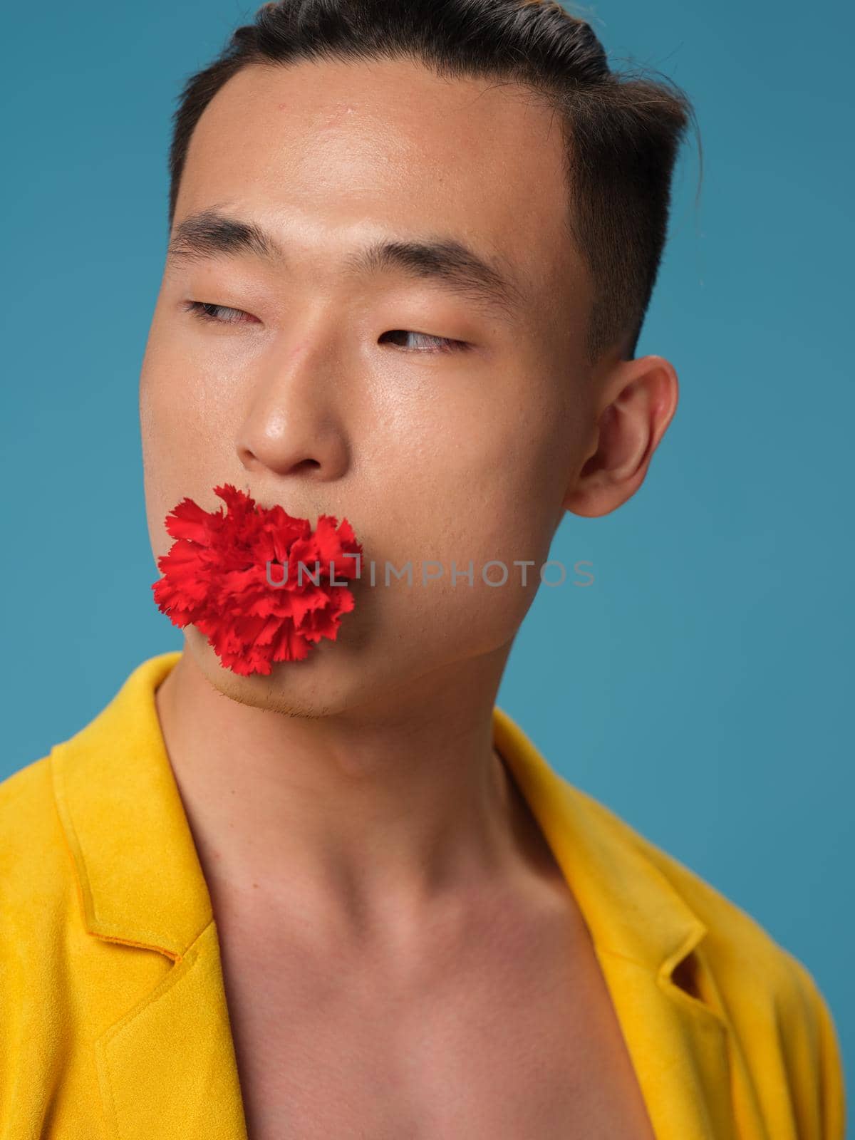 Portrait of a Korean man with a red flower in his mouth . High quality photo