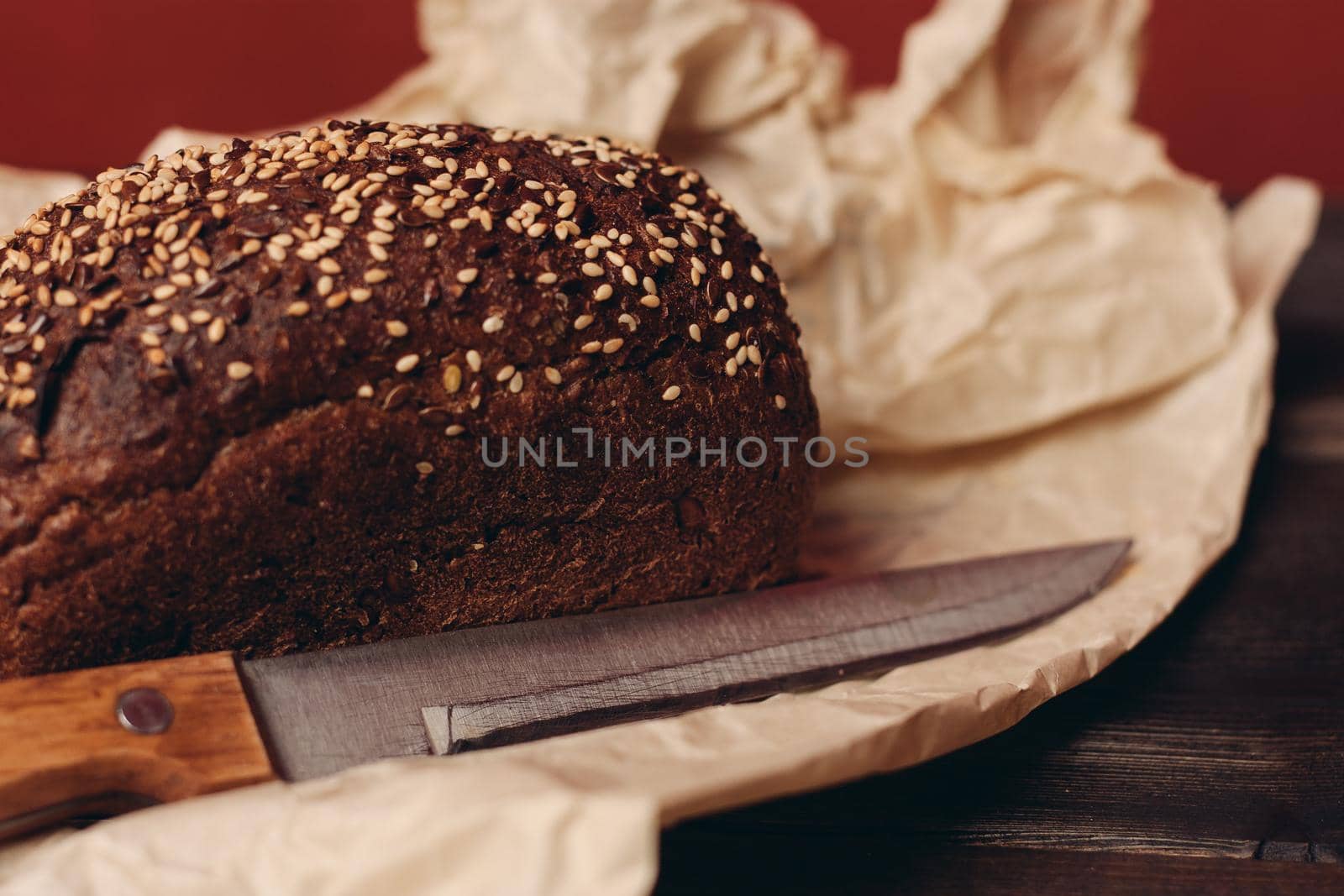 rye bread baking on paper packaging wooden table and sharp knife. High quality photo