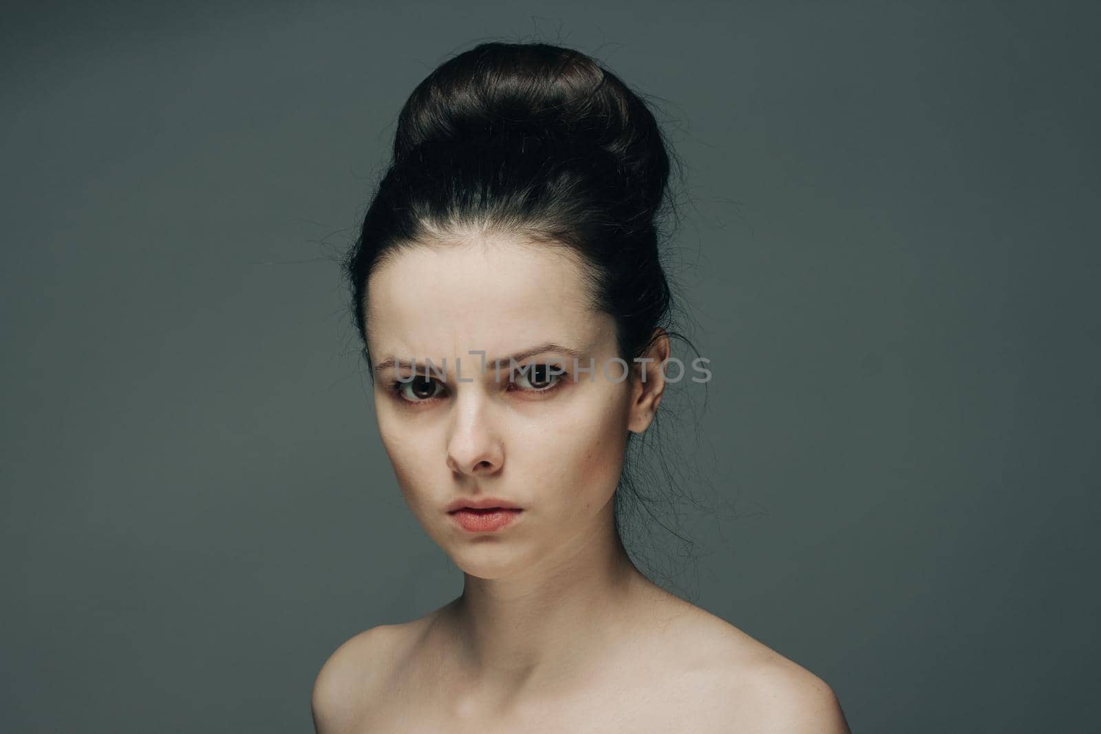 beautiful brunette with bare shoulders on gray background cropped view. High quality photo