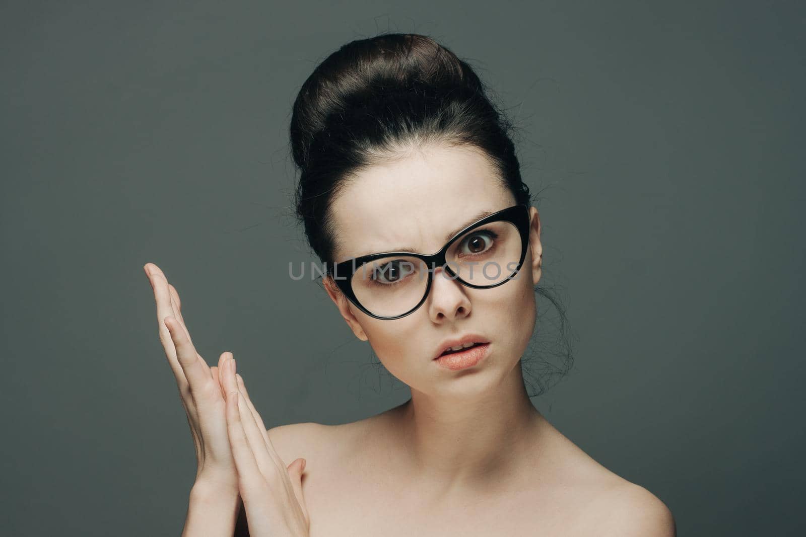 woman with bare shoulders wearing glasses gathered hair charm. High quality photo