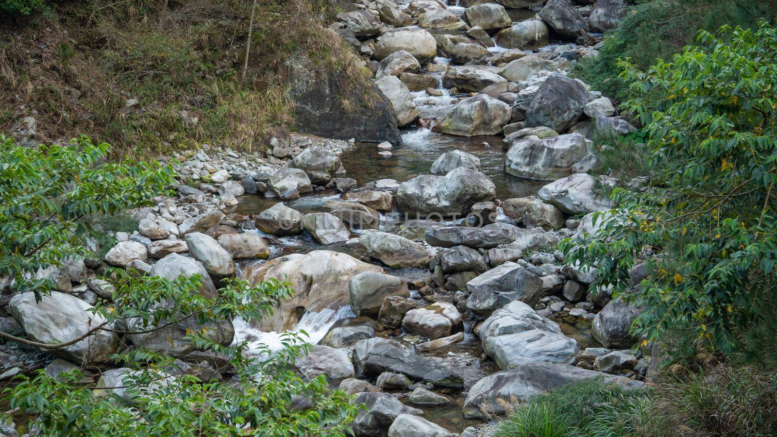Wild river flow in forest with rock stones landscape in Taiwan.