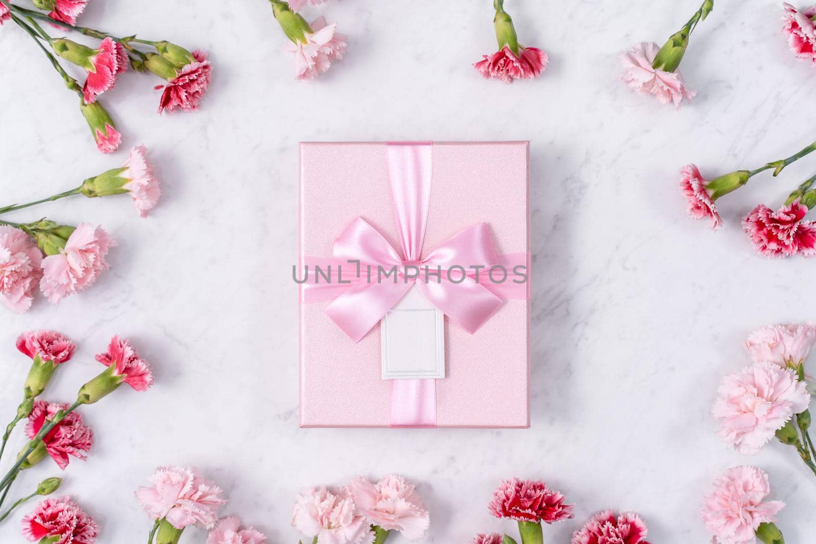 Concept of Mother's day holiday greeting gift design with carnation bouquet on white marble background