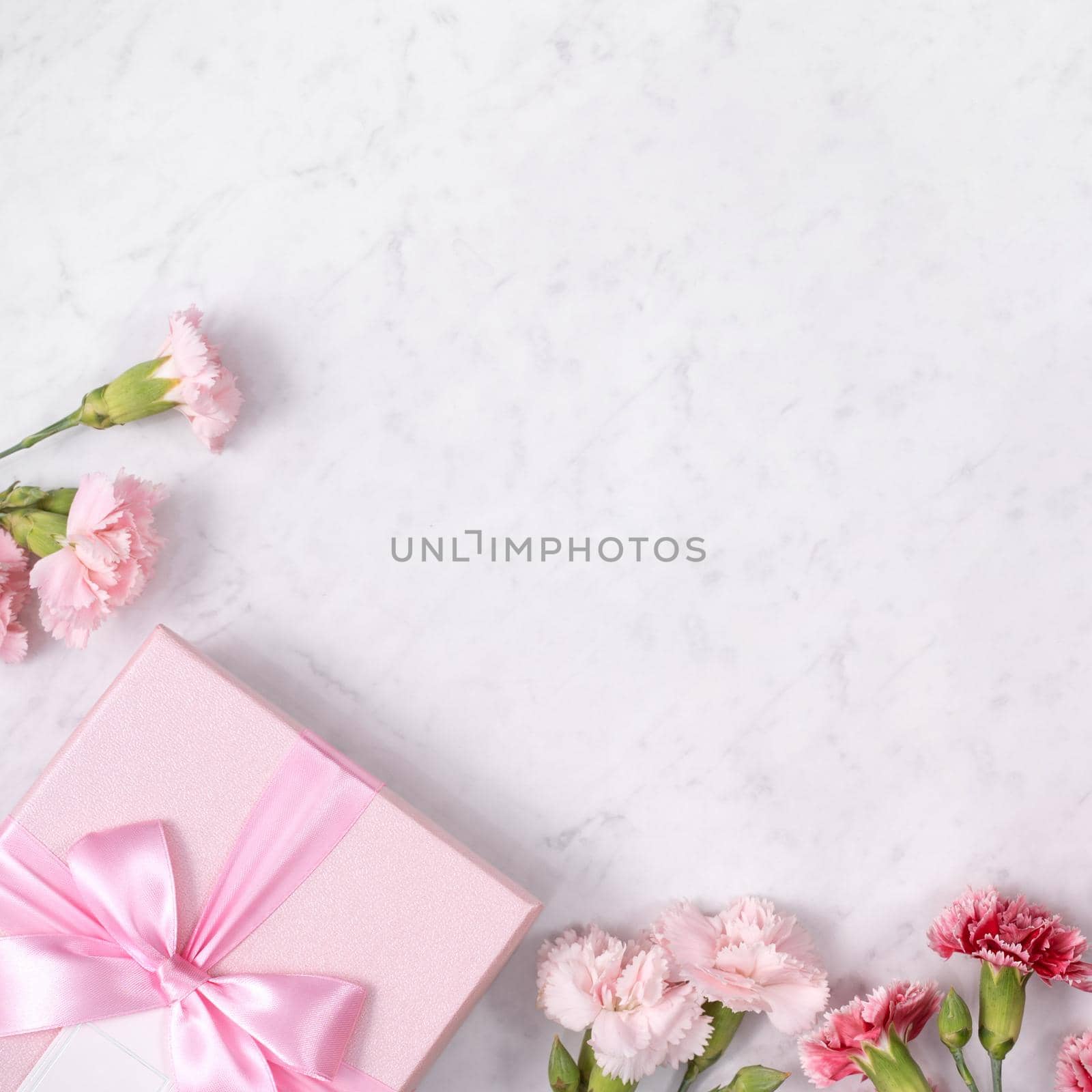 Concept of Mother's day holiday greeting gift design with carnation bouquet on white marble background
