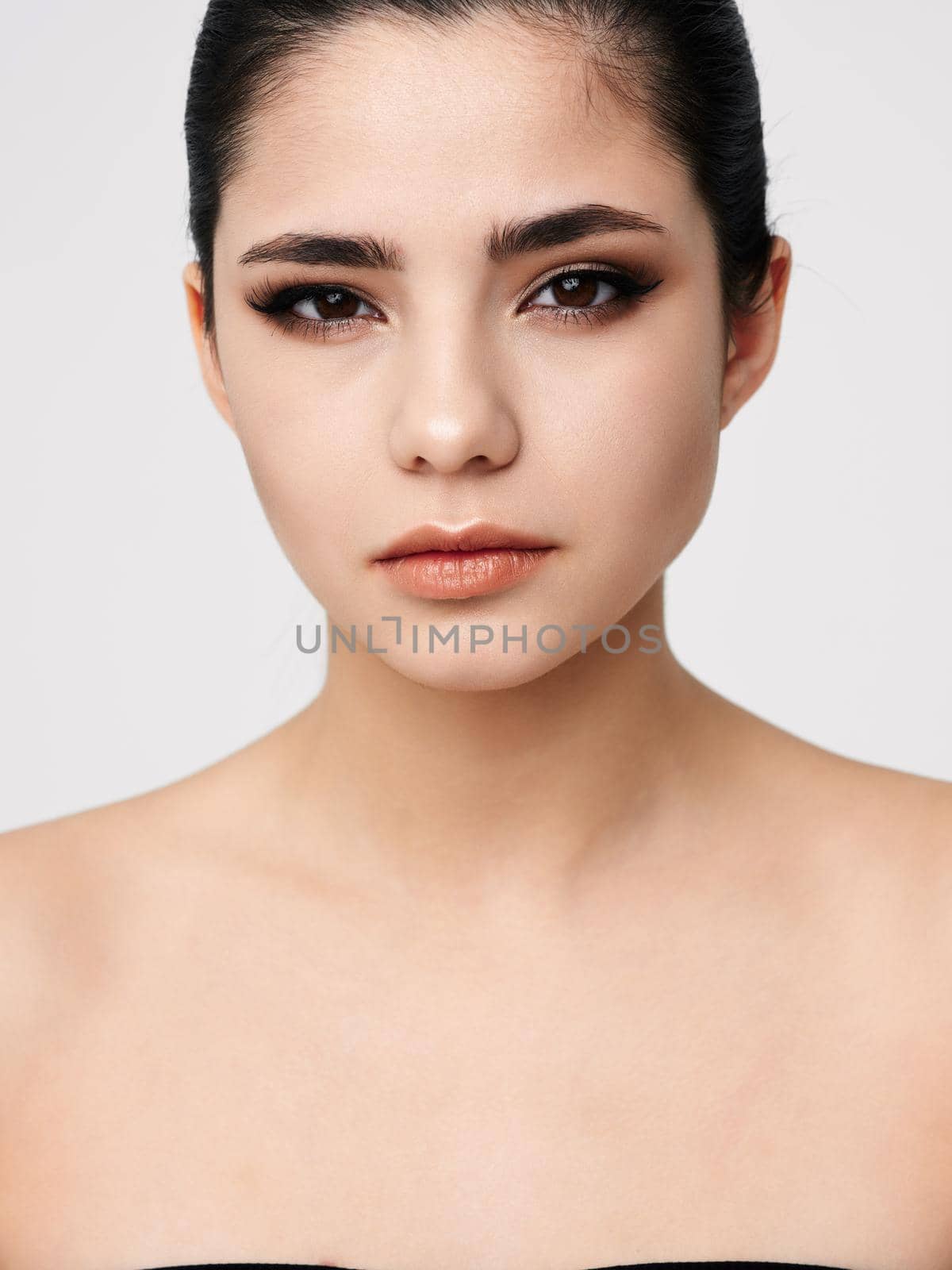 attractive brunette naked shoulders makeup facial closeup. High quality photo