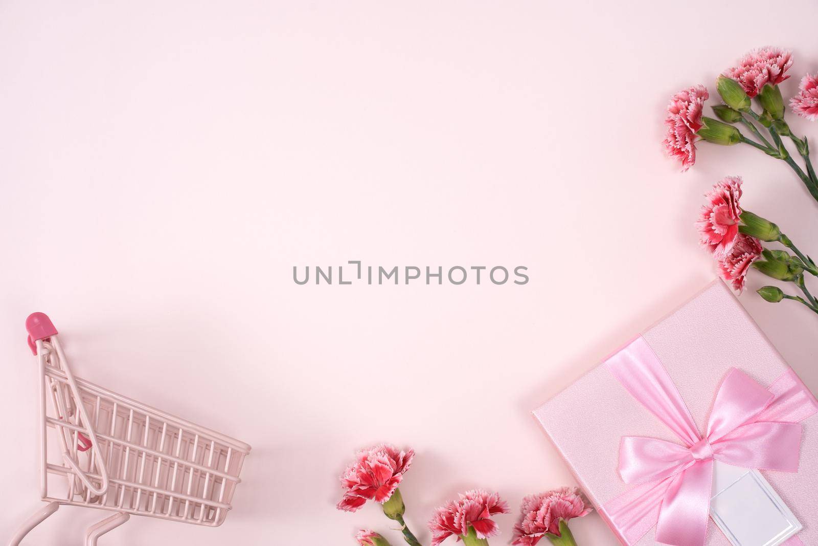 Concept of Mother's day holiday greeting design with carnation bouquet and gift on pink background