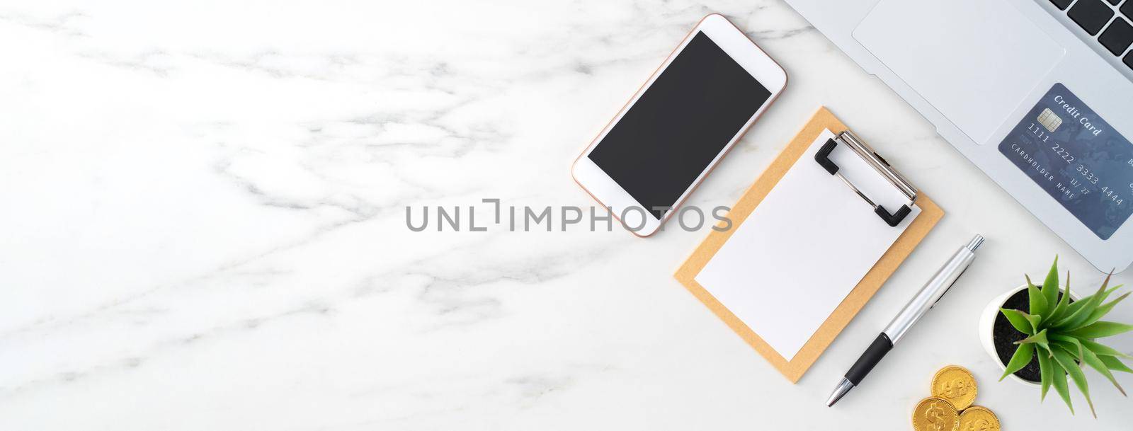 Top view of financial plan concept with credit card, laptop, note on white office table background.