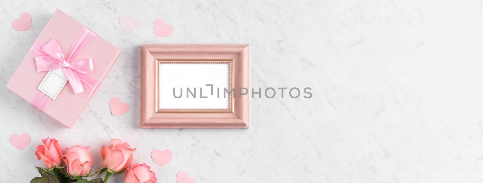 Giftbox and pink rose flower on marble white table background for Mother's Day holiday greeting design concept.
