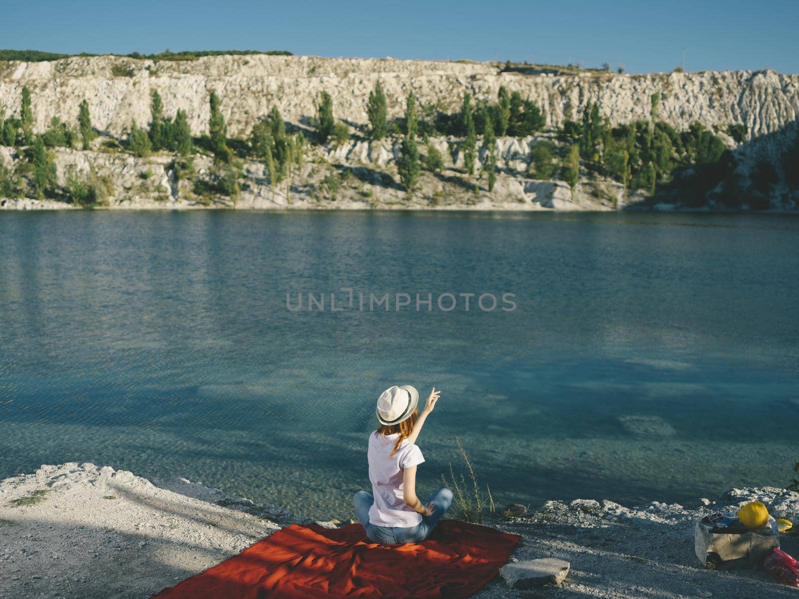 Happy woman resting in nature near the river and red cloth on the bank. High quality photo