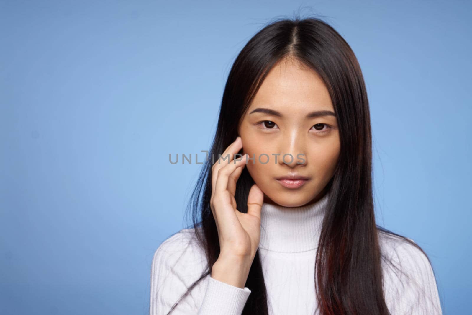 pretty woman with dark hair in white sweater gestures with her hands clean skin cosmetology. High quality photo