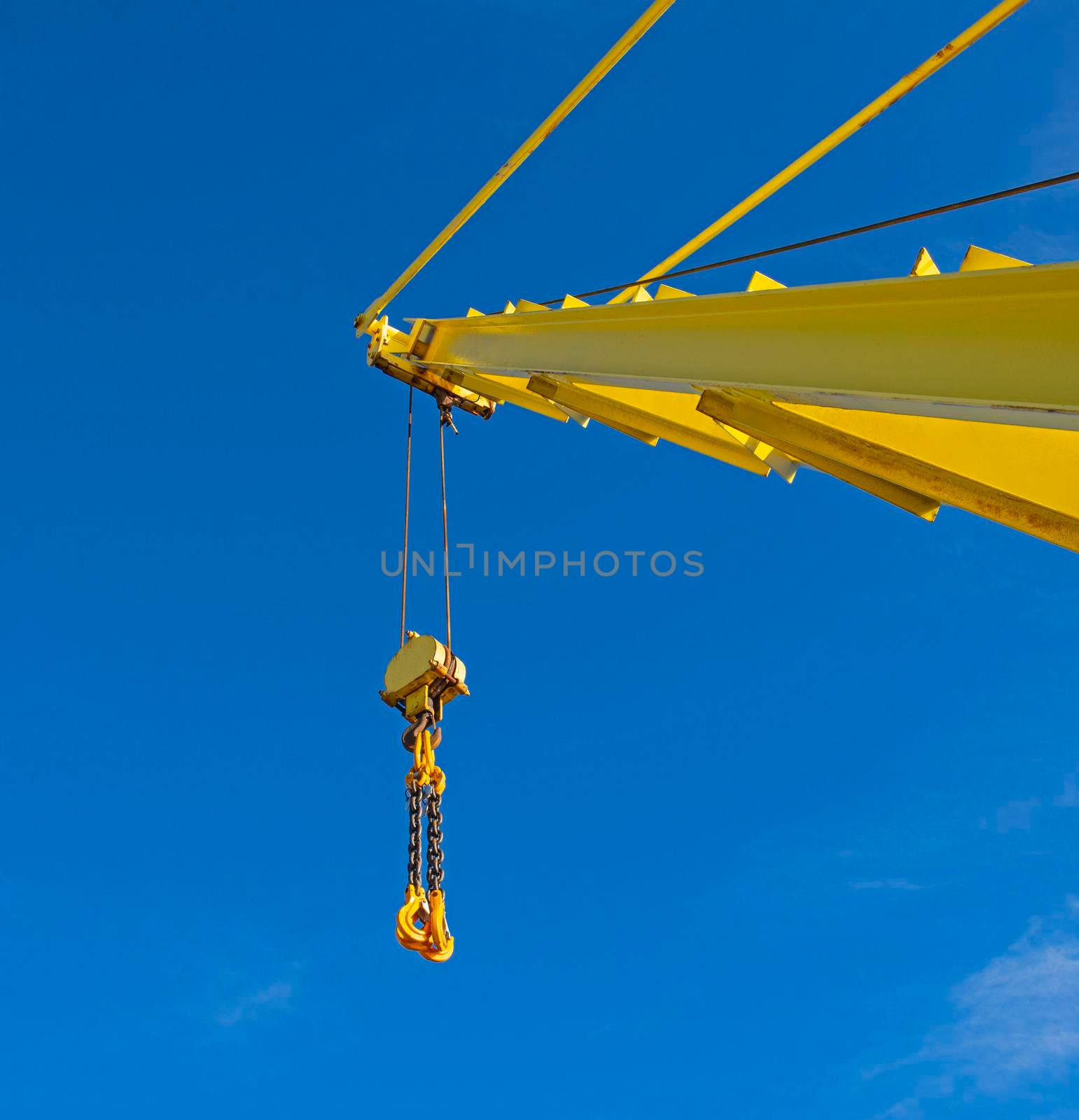 Large crane jib against blue sky background by paulvinten