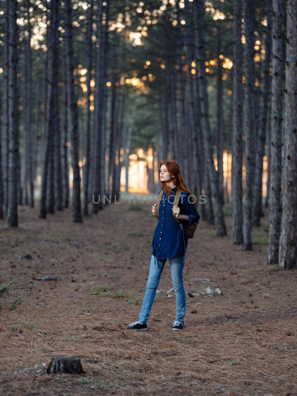 Pretty woman travels in the forest with a backpack on her back and in a blue shirt by SHOTPRIME