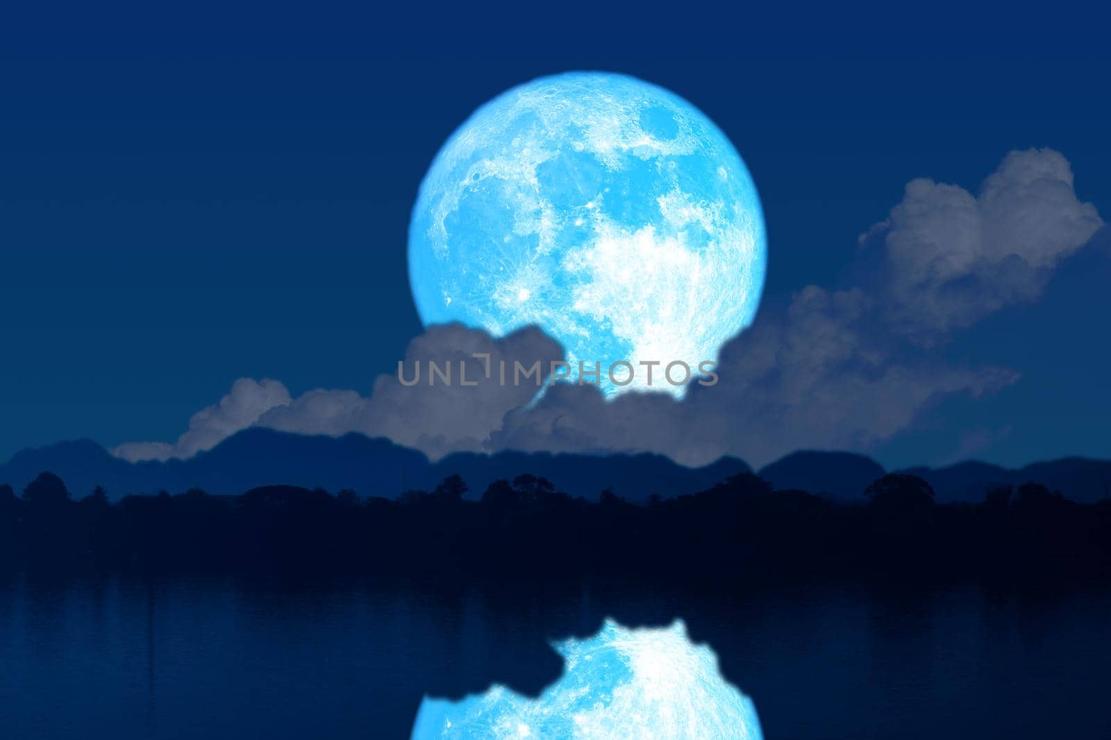 Super blue worm blue moon rise back silhouette mountain blur dark cloud on the night sky and reflection on water surface, Elements of this image furnished by NASA