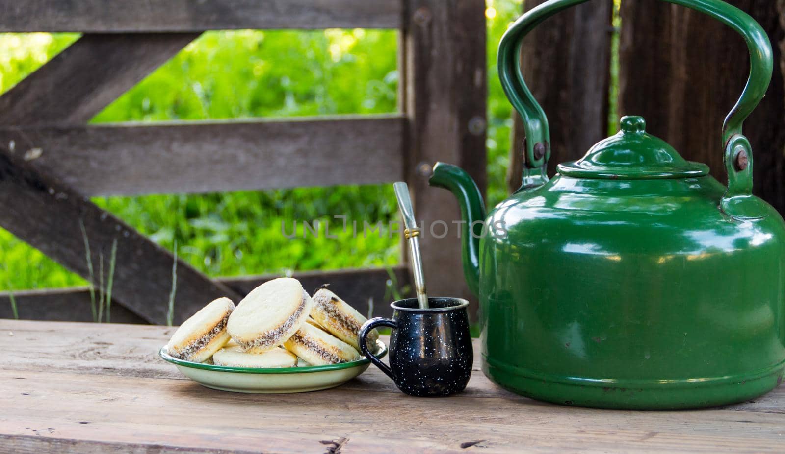 Mate and kettle with a plate of alfajores and yerba mate infusion in the Argentine countryside by GabrielaBertolini