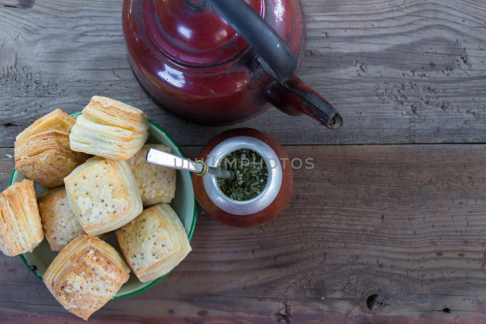 Mate and kettle with a plate of salty Argentine biscuits and yerba mate infusion