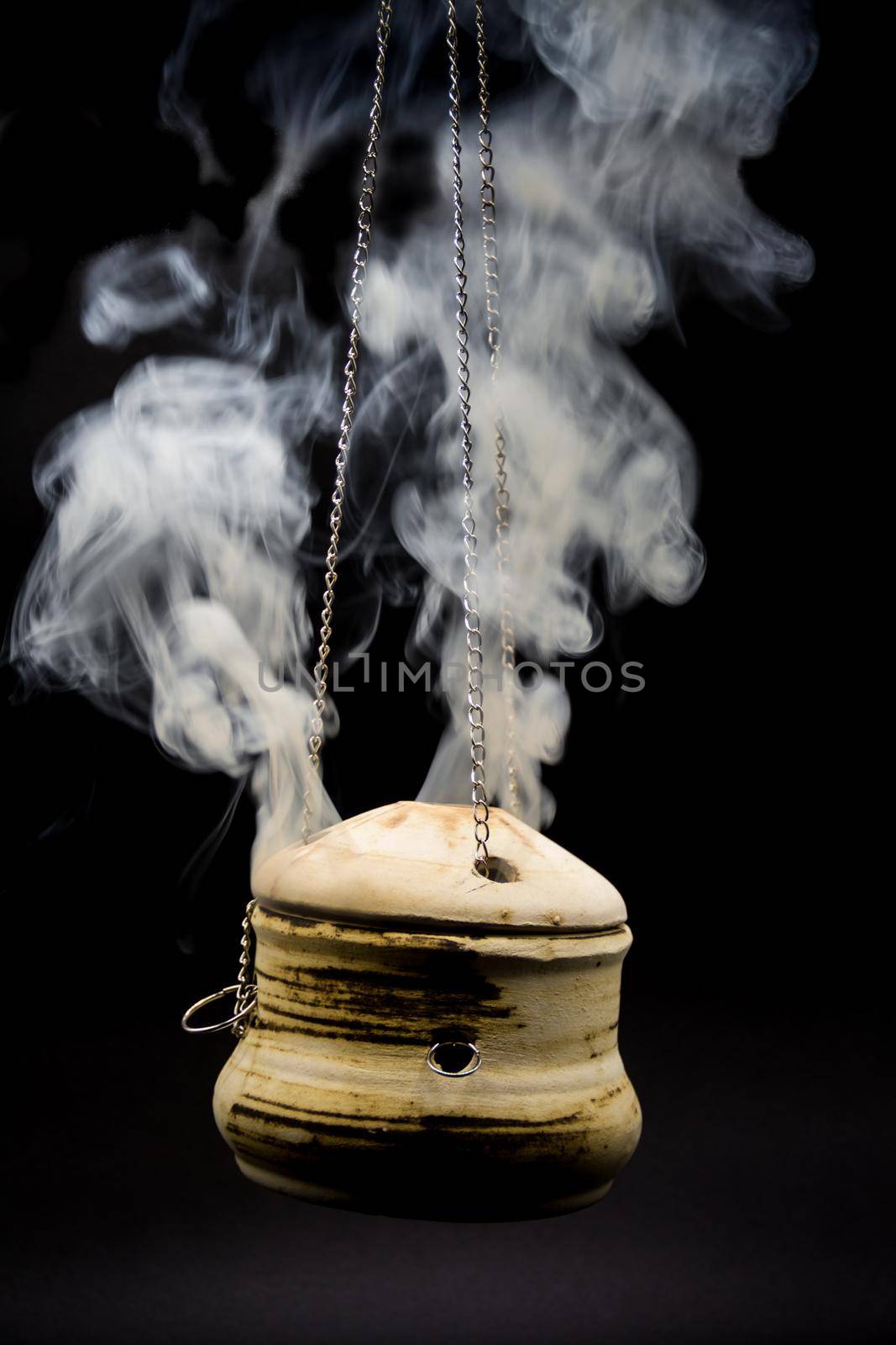 bowl of incense hanging smoke on black background by GabrielaBertolini