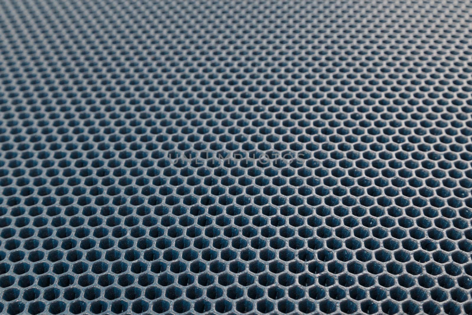 blue hexagonal punched EVA - ethylene vinyl acetate foam carpet linear perspective background with selective focus.