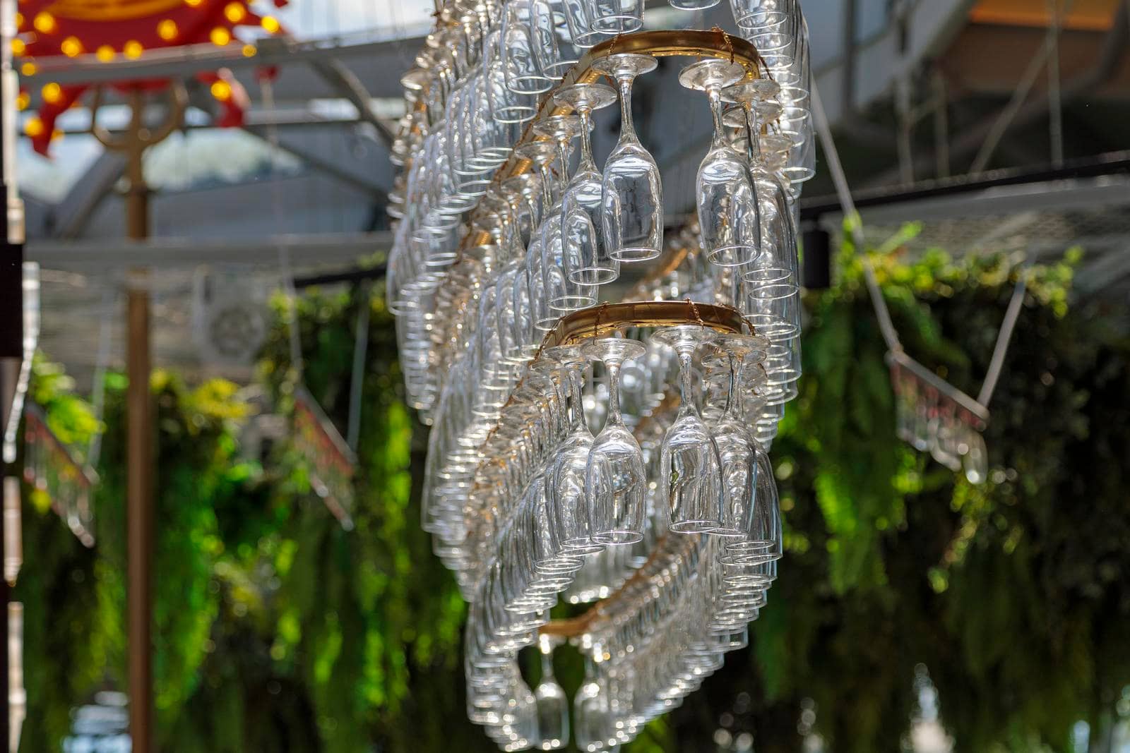 Several rows of champagne glasses hang on a chandelier-shaped counter. Decorative modern chandelier.