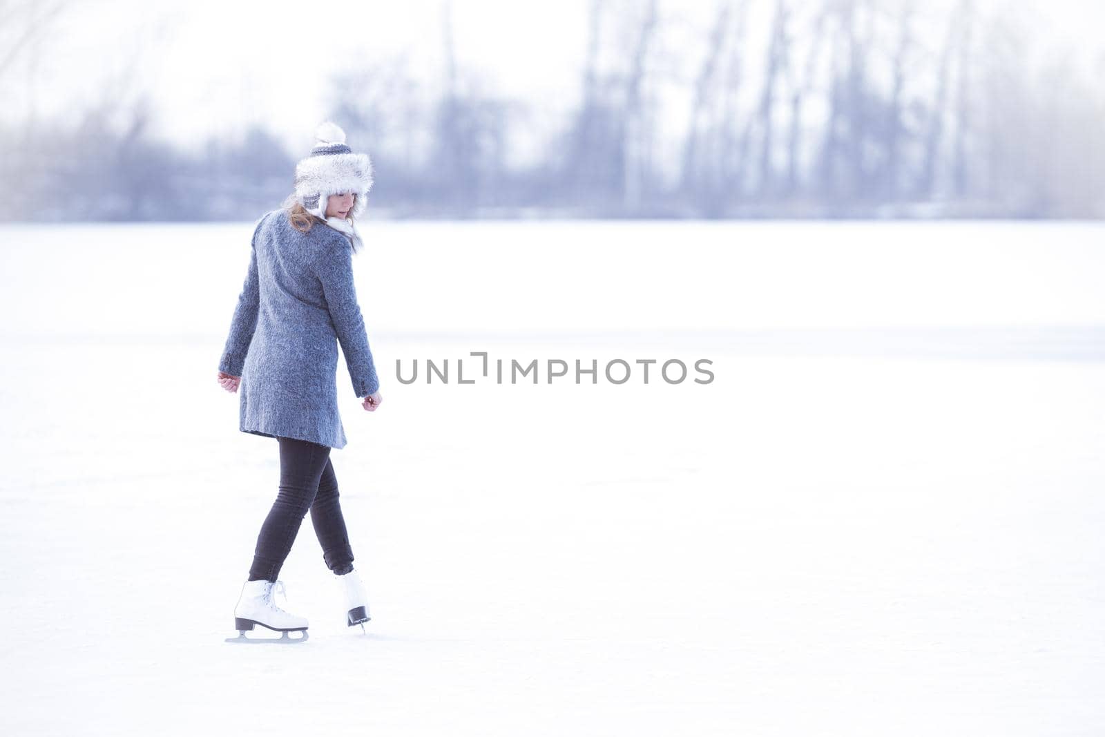 young woman skating on a frozen pond by Edophoto