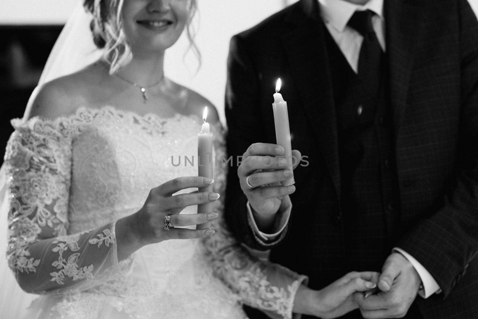 atmospheric decor of candles with live fire in the hands of the newlyweds by Andreua