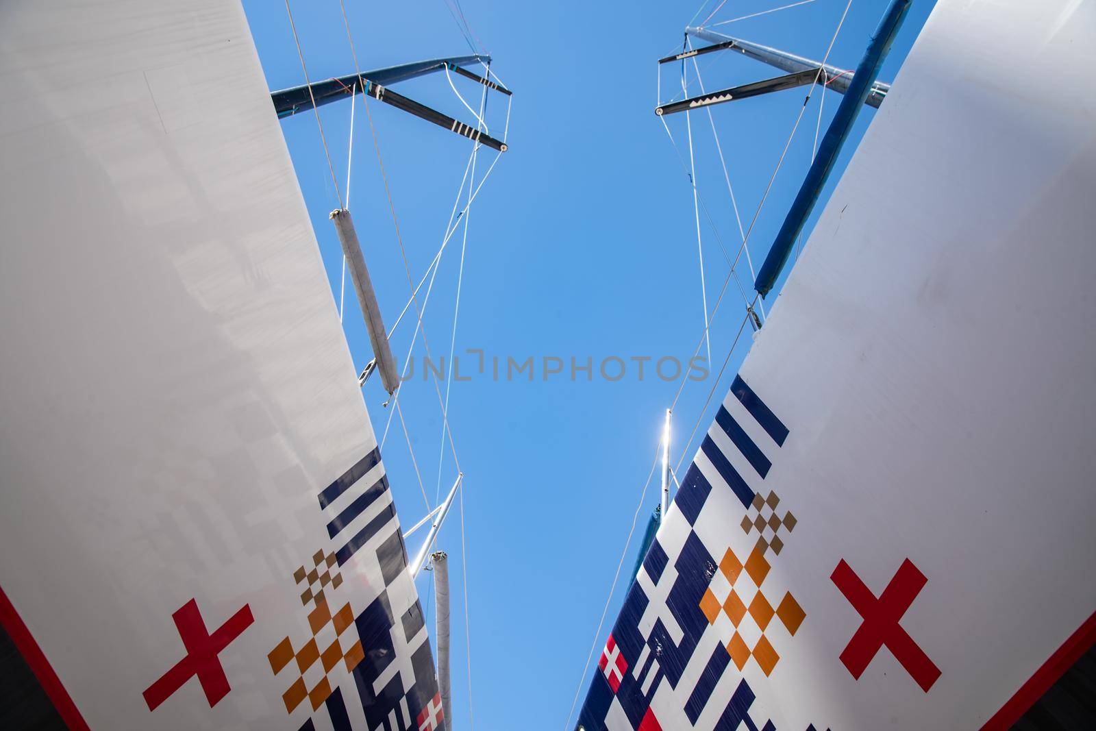 Russia, St.Petersburg, 26 May 2020: Port Hercules, the sailboats stand on supports, the bottom view, masts and the slings, a clear sunny weather, the blue sky, the bottom of the boat and kiel by vladimirdrozdin