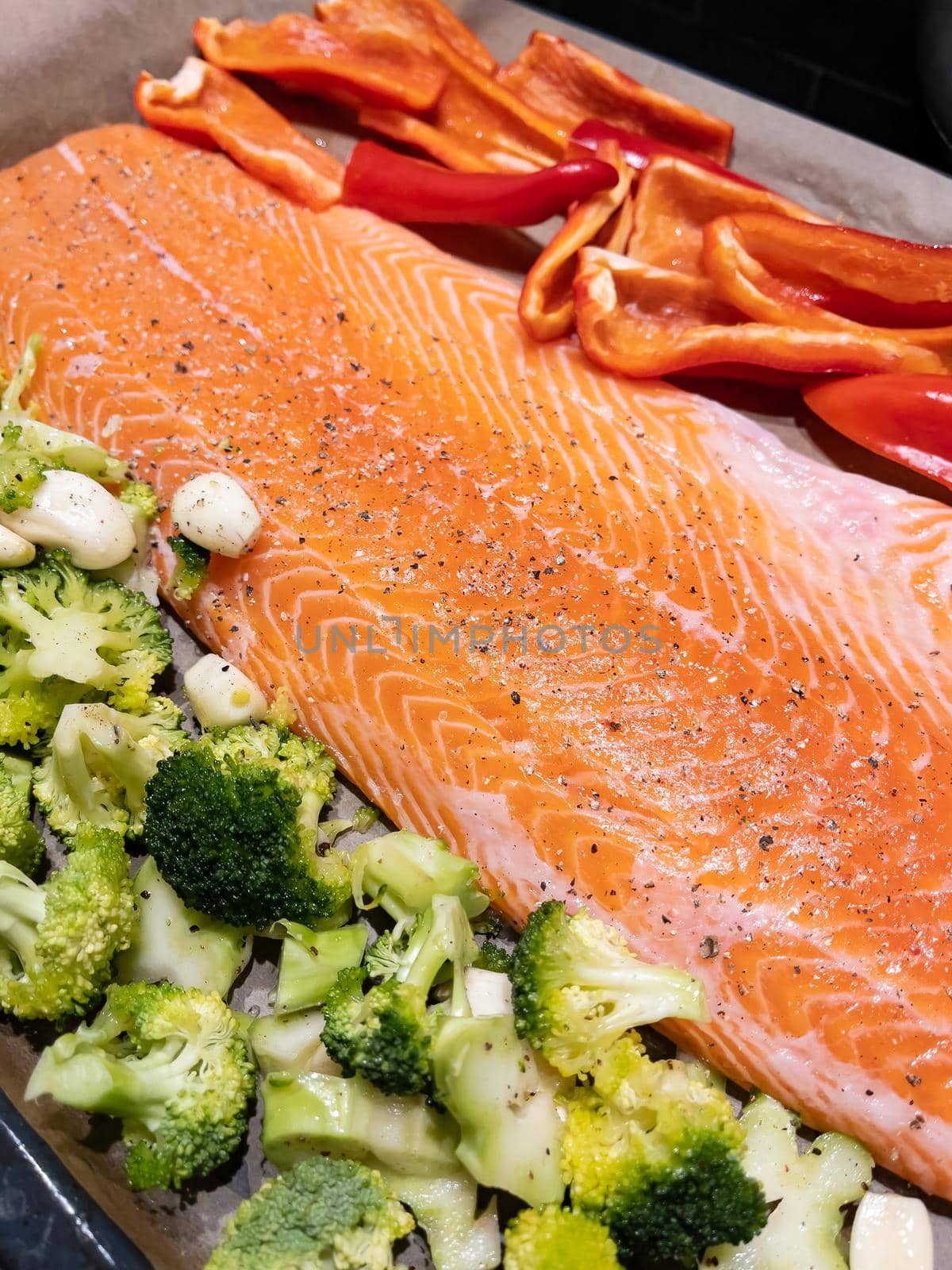A large piece of red fish fillet lies on the prostena, vegetables ready to be locked, broccoli, red sweet pepper. High quality photo