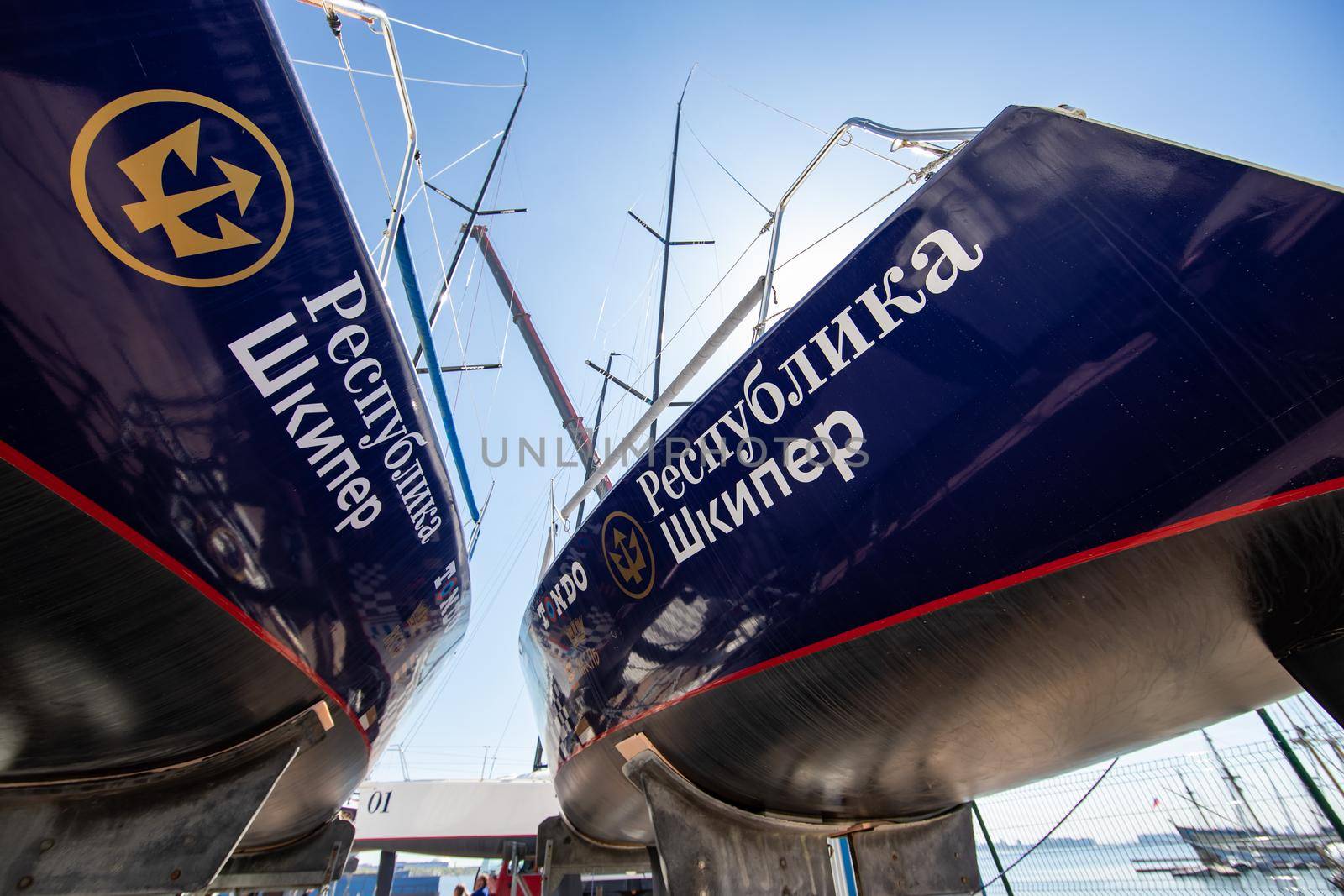 Russia, St.Petersburg, 26 May 2020: Port Hercules, the sailboats stand on supports, the bottom view, masts and the slings, a clear sunny weather, the blue sky, the bottom of the boat and kiel, logo