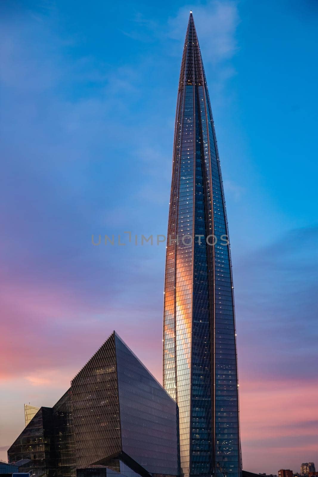 Russia, St.Petersburg, 03 July 2020: The color image of skyscraper Lakhta center at sunset, Reflection of the sunset sky in a glass facade of the building, It is the highest skyscraper in Europe by vladimirdrozdin