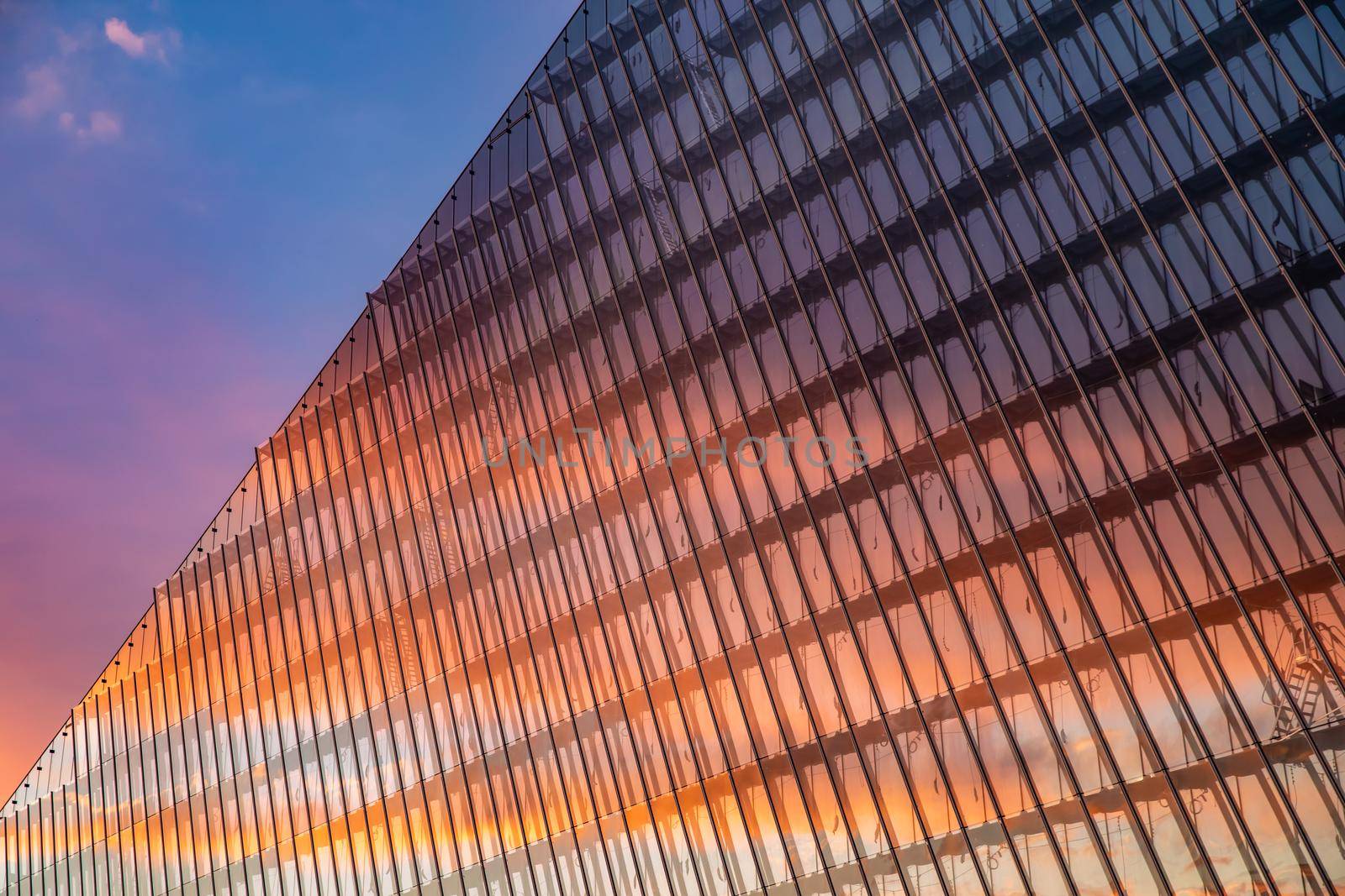 Reflection of the sunset sky in a glass facade of the building, skyscraper at sunset, pink sky by vladimirdrozdin