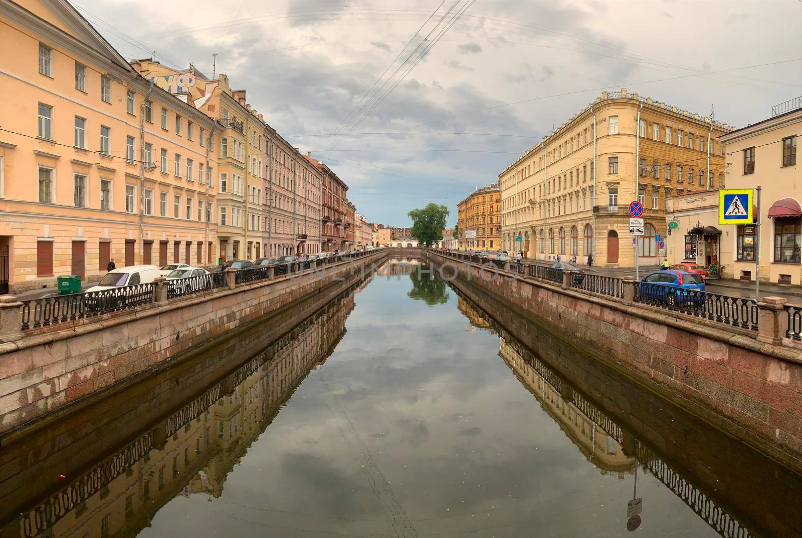 Russia, St.Petersburg, 09 June 2020: Griboyedov Canal, specular reflection in water, architecture of St. Petersburg, the bridge through the river
