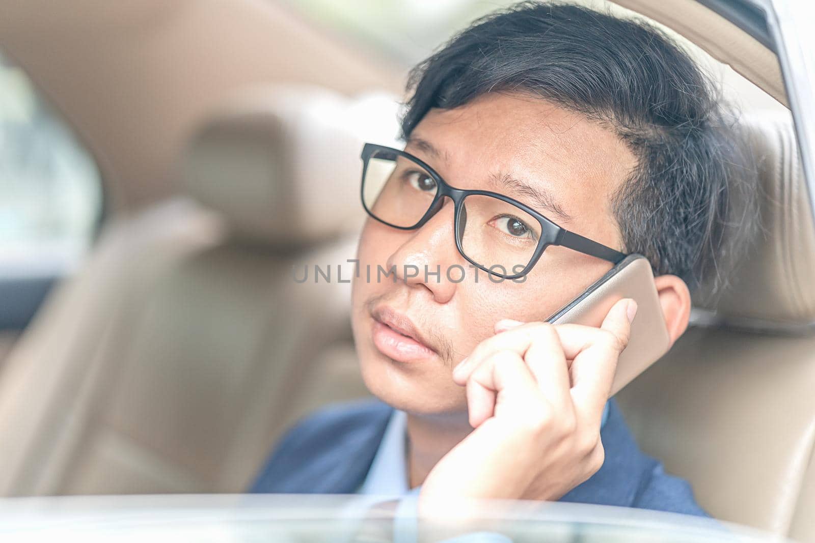 Young asian business men portrait in suit working in the backseat of a car