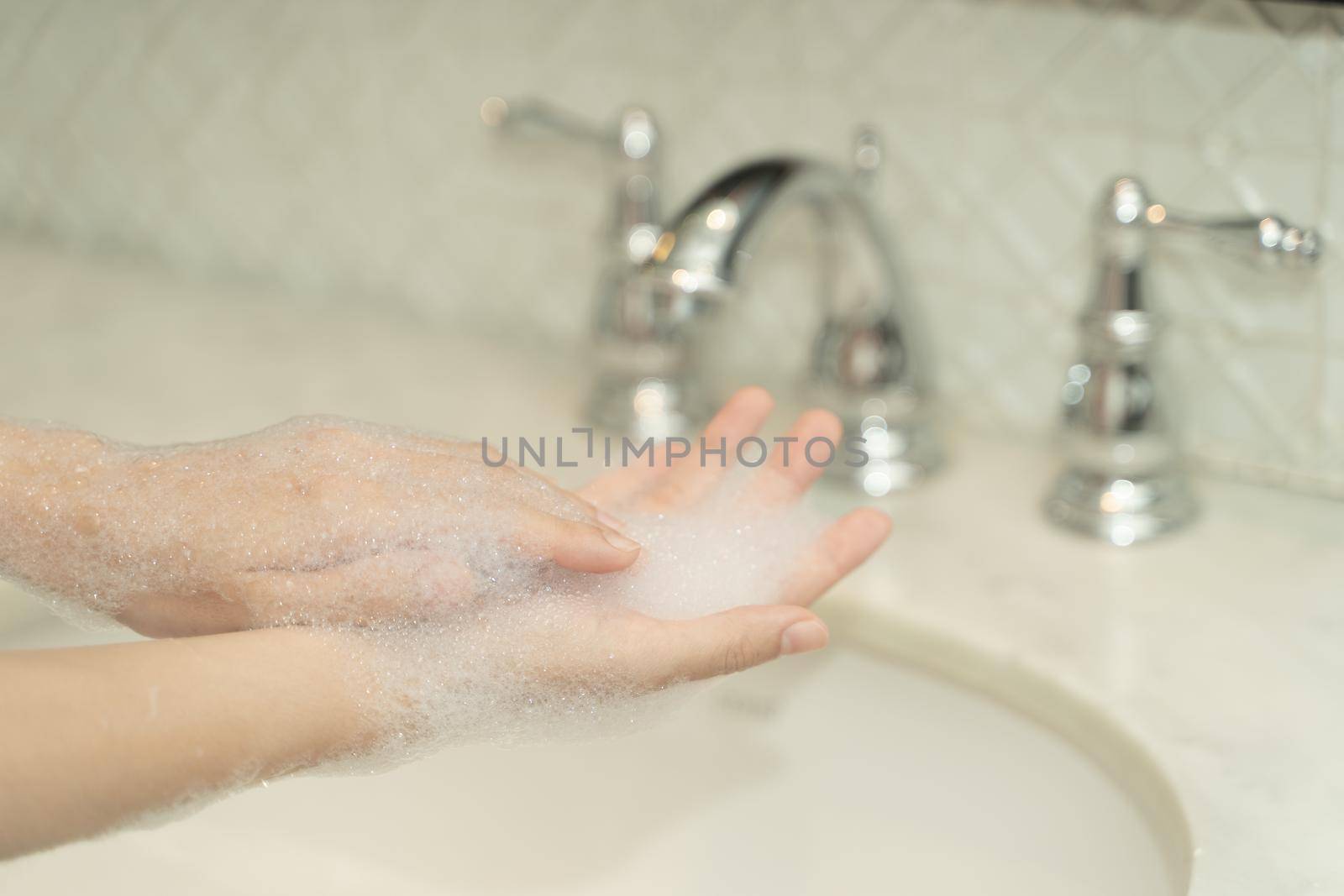 Woman hand use soap and washing under the water tap. Hygiene concept.