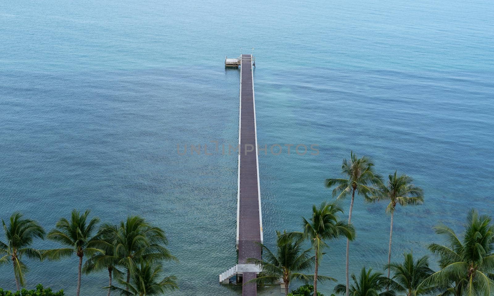 The bridge in to the sea. Tropical view with a concrete bridge to a pier on blue ocean. top view. by sirawit99