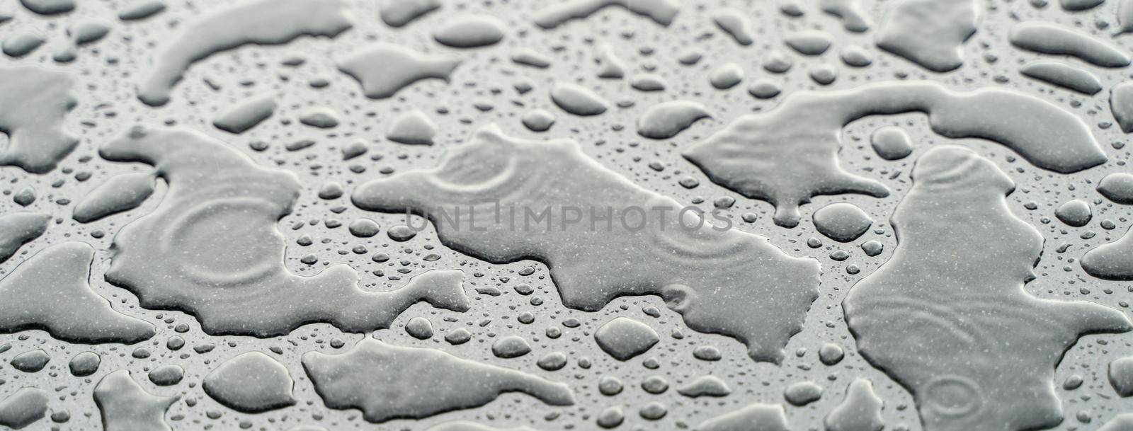 Drops of water on the car after rain. Water drops on top of metal surface.