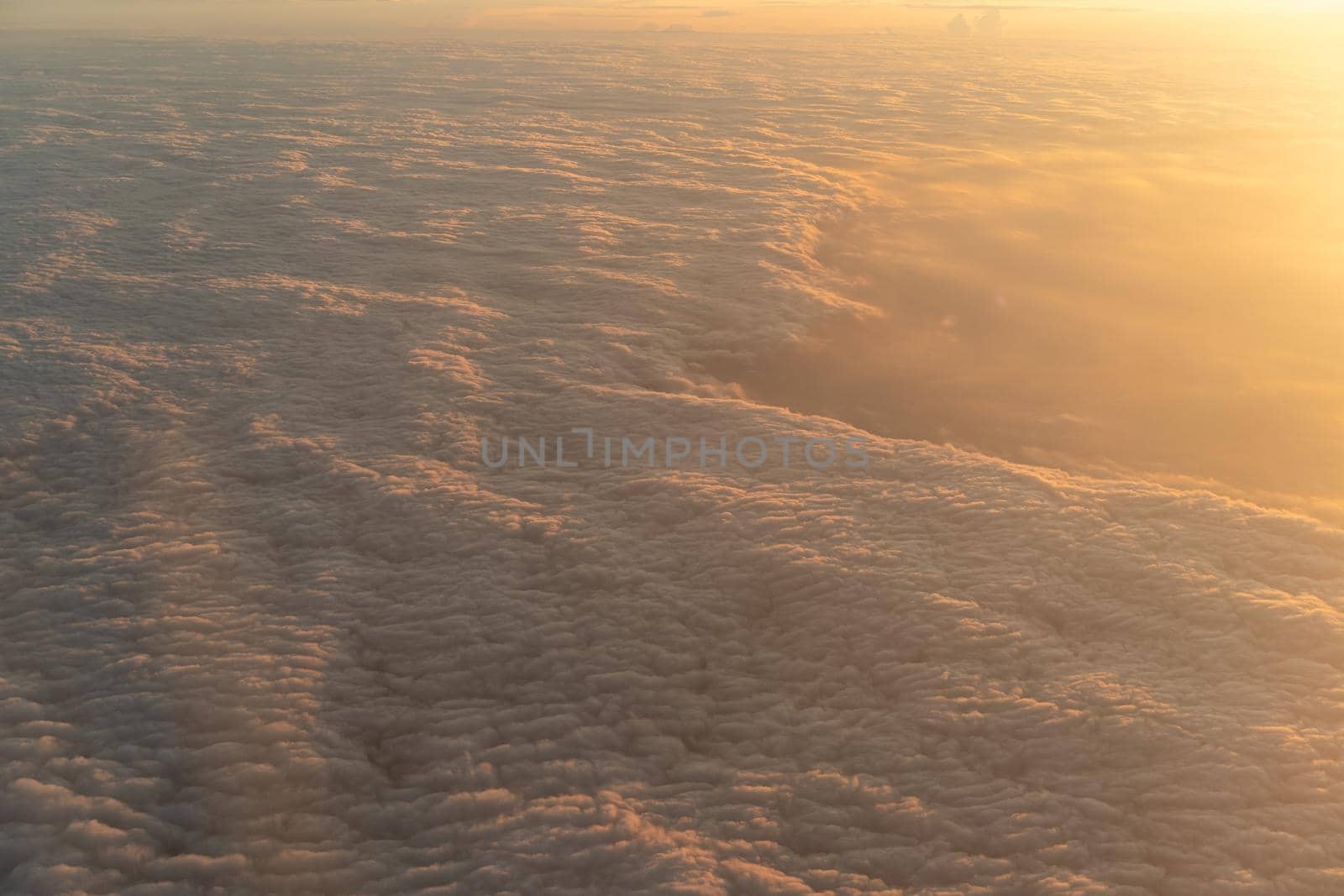 Dramatic sunset scenic. View of sunset above clouds from airplane window.