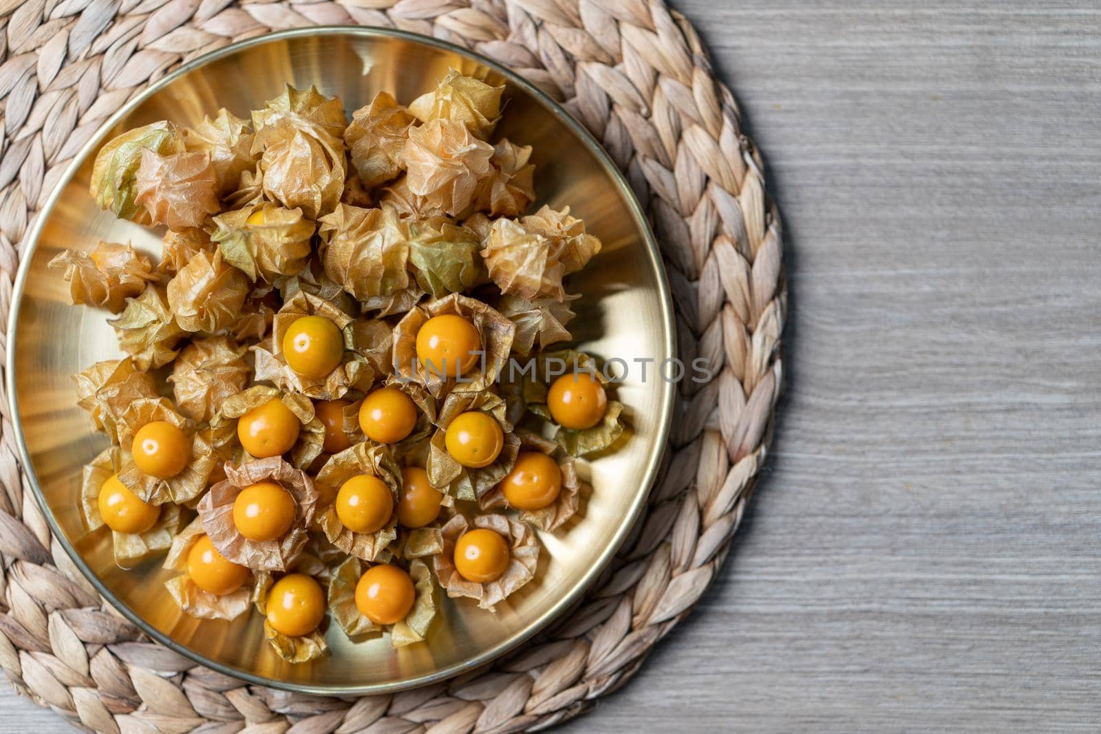 Top view pile of cape gooseberry fruit in the gold plate. by sirawit99