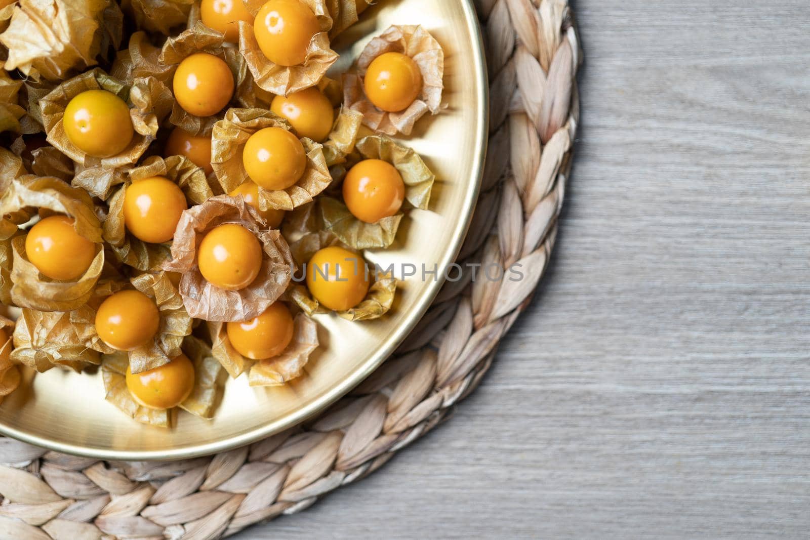 Top view pile of cape gooseberry fruit in the gold plate. by sirawit99