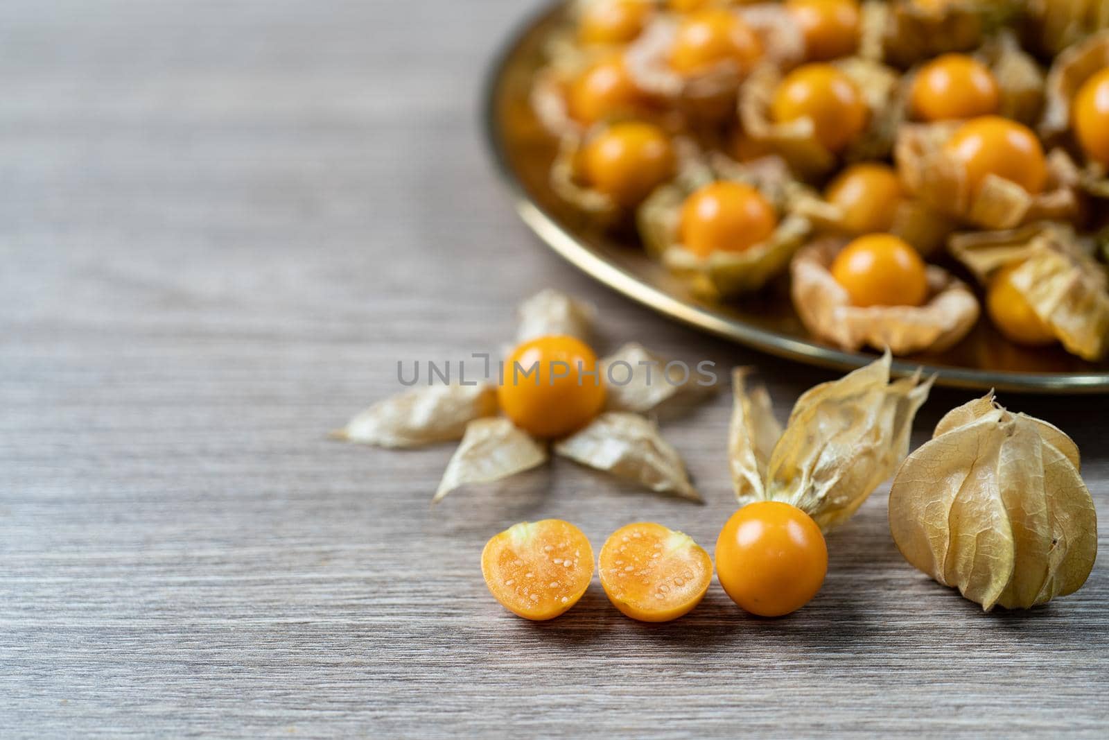 Top view pile of cape gooseberry fruit in the gold plate. by sirawit99