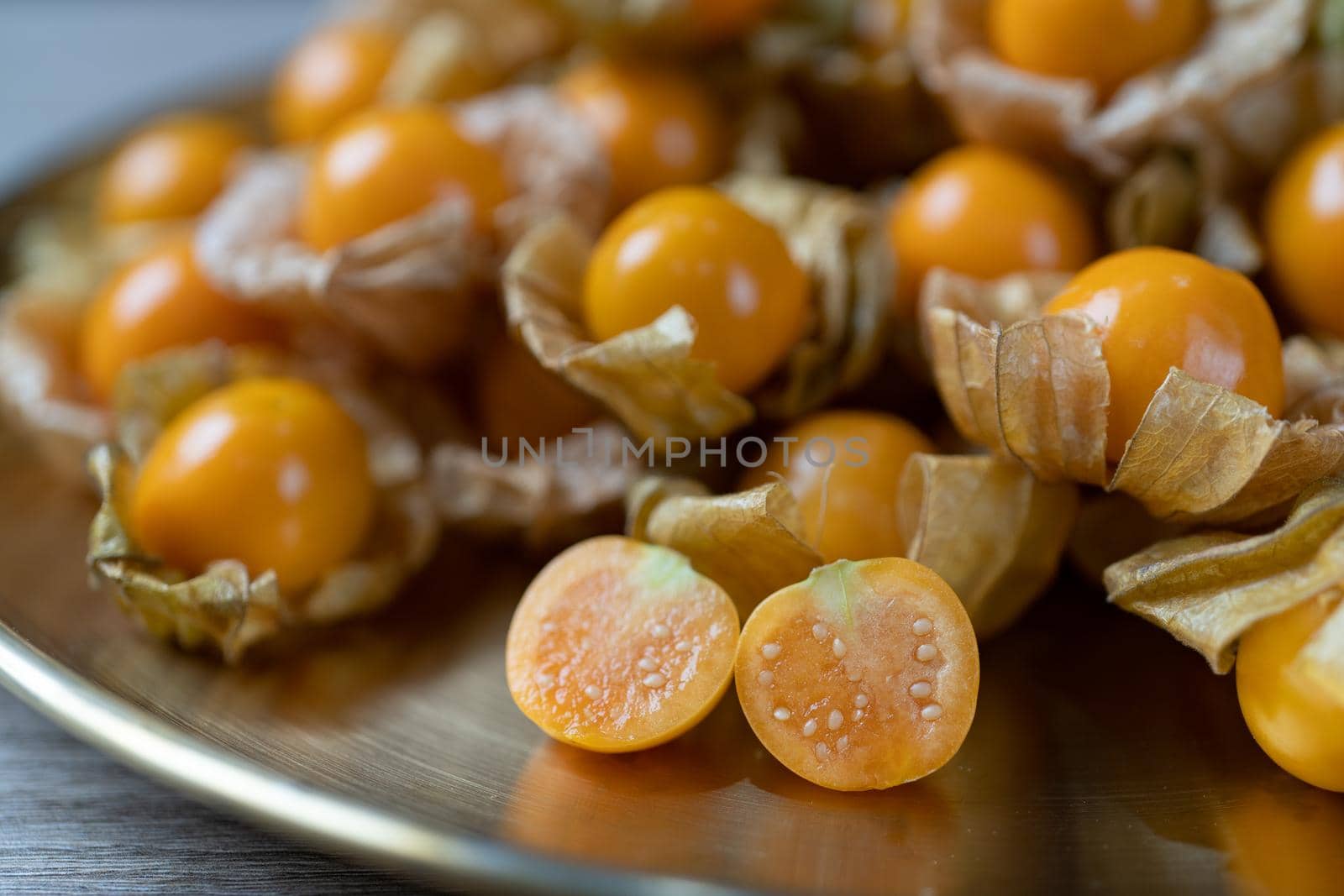 Top view pile of cape gooseberry fruit in the gold plate. by sirawit99