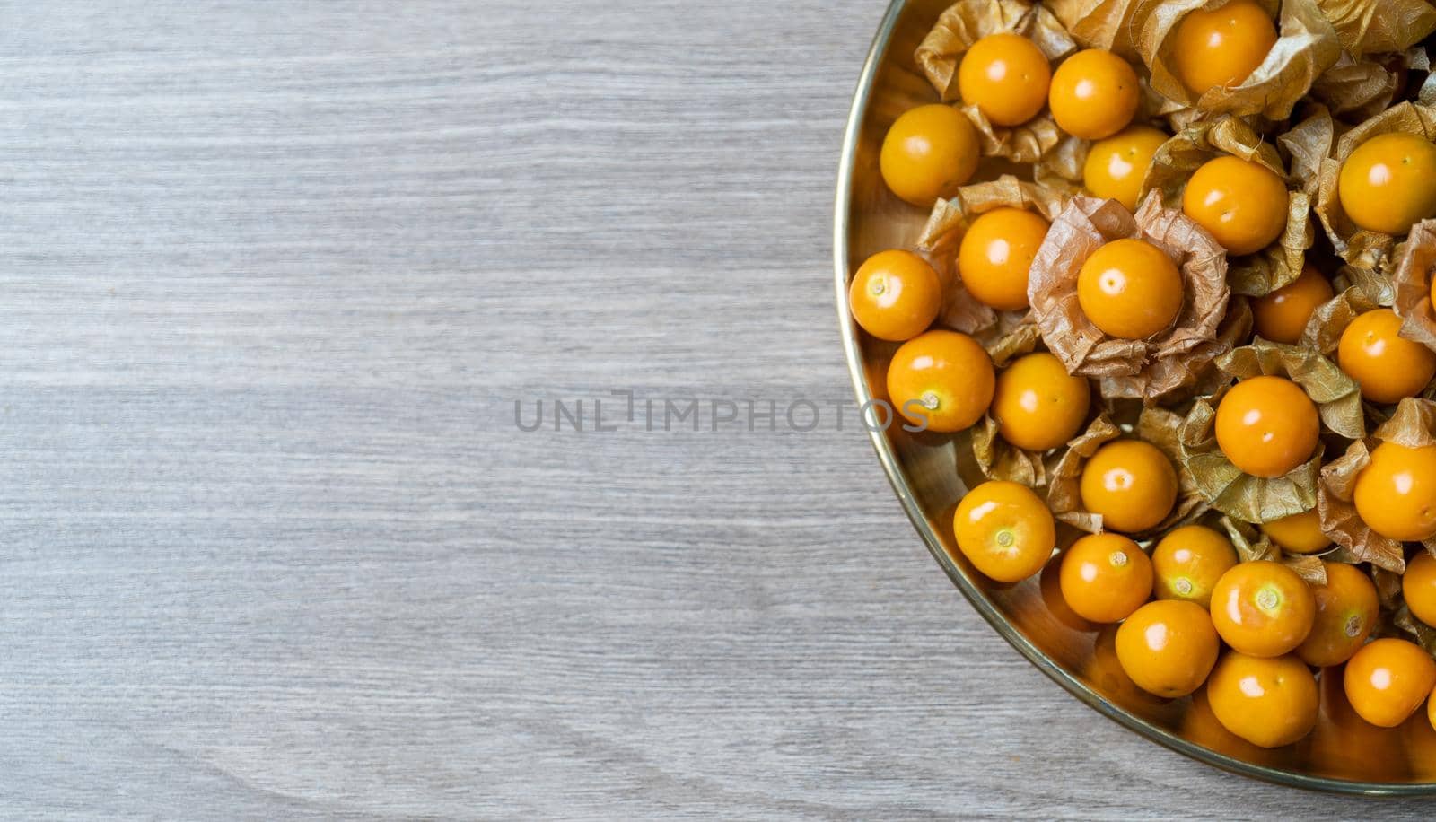 Top view pile of cape gooseberry fruit in the gold plate. by sirawit99