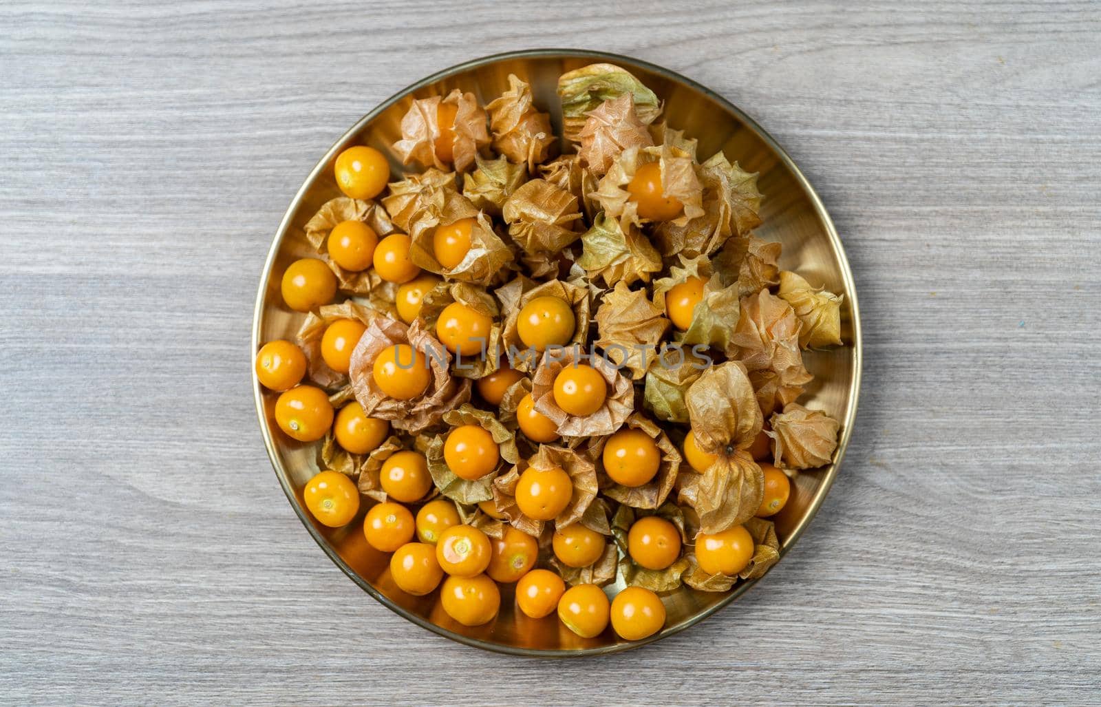 Top view pile of cape gooseberry fruit in the gold plate. by sirawit99