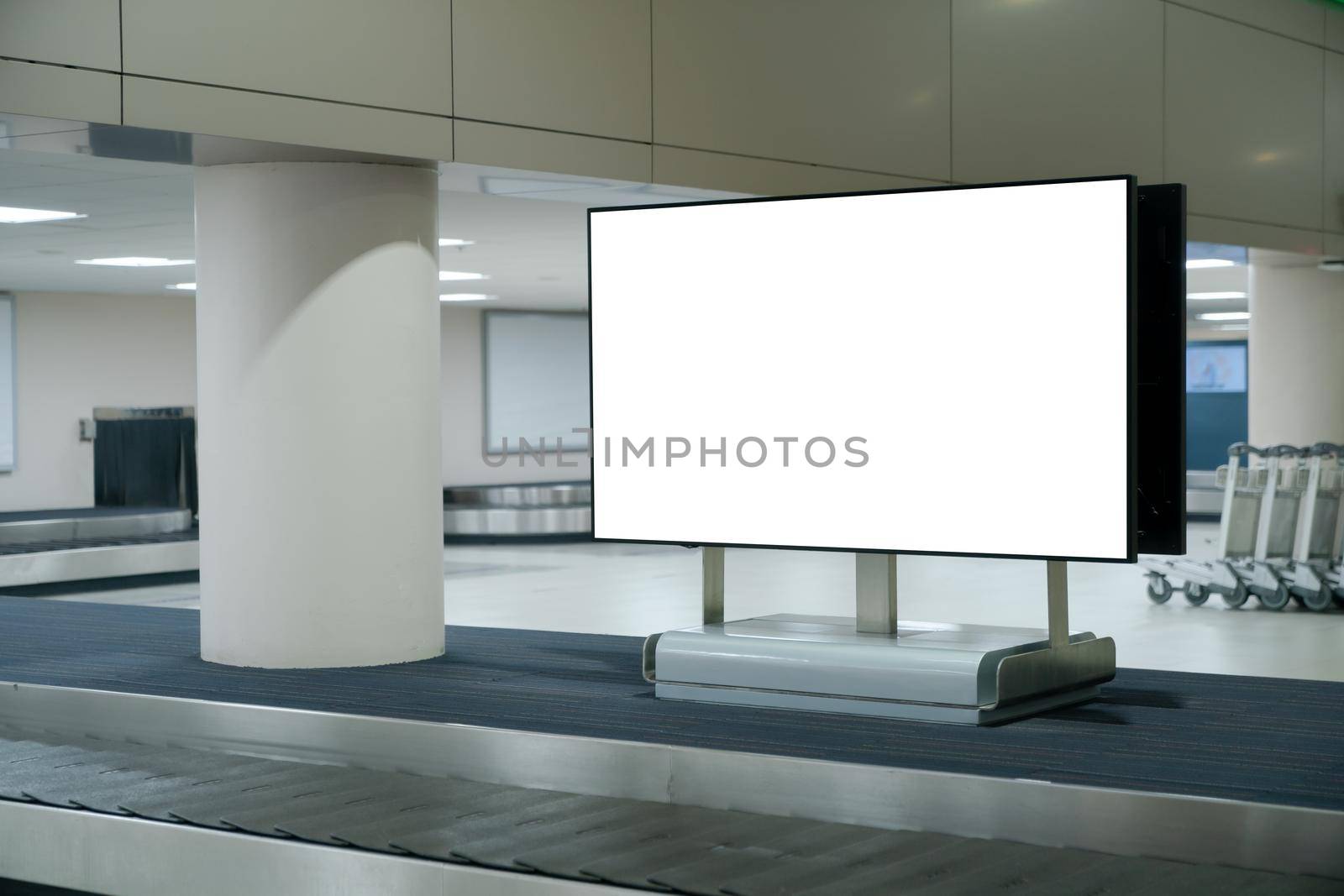 Mockup blank screen at conveyor belt luggage in airport. White screen for text advertise.