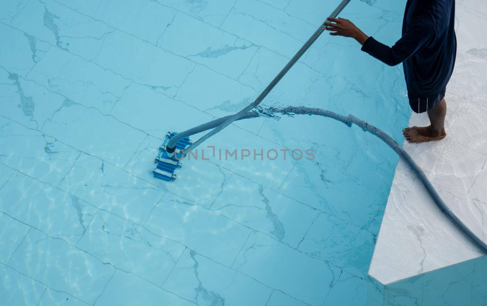 Man is cleaning service and maintenance of the pool. Swimming pool cleaning. by sirawit99