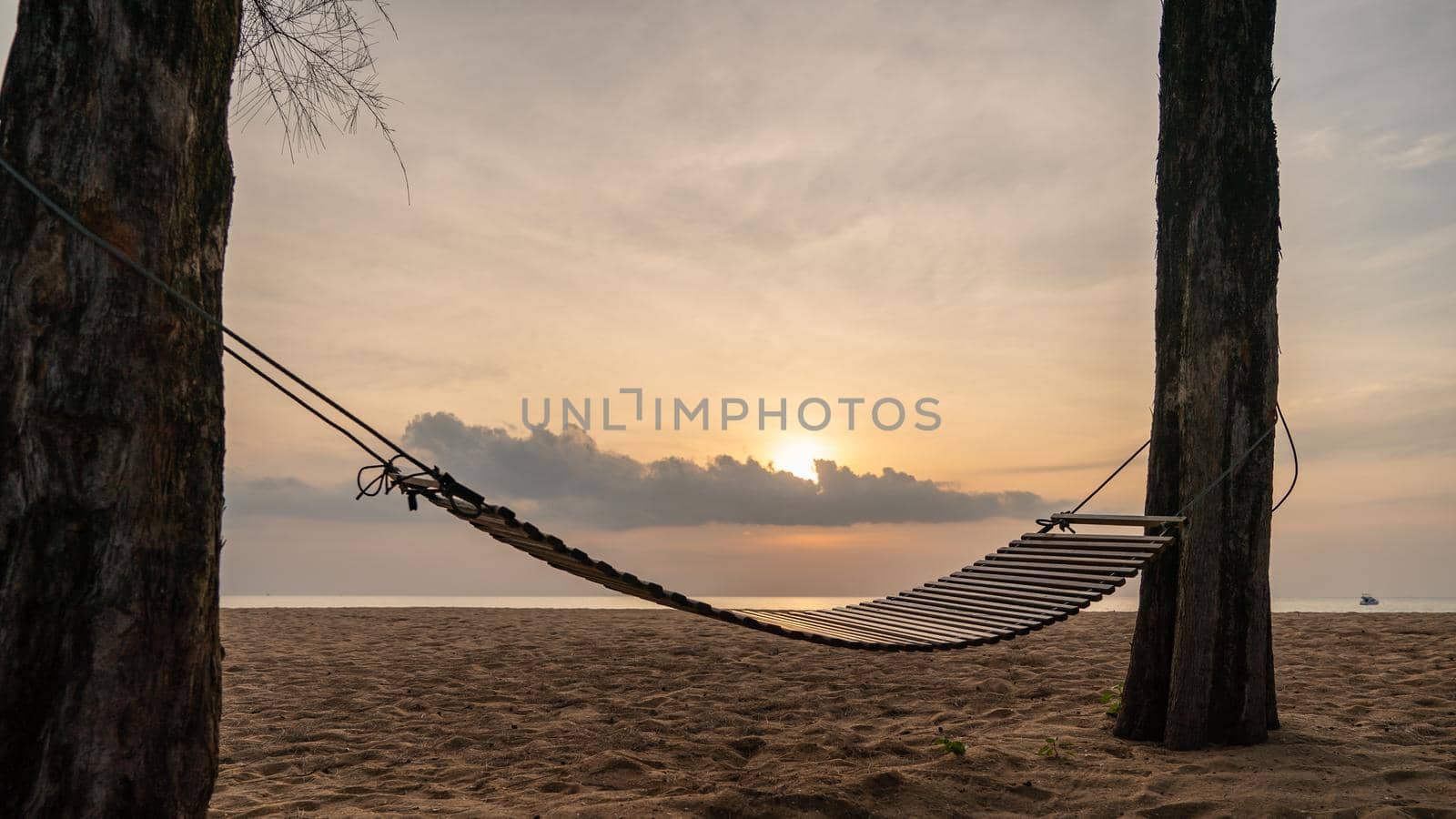 A wooden swing or cradle on the beach with beautiful cloud and sky. by sirawit99