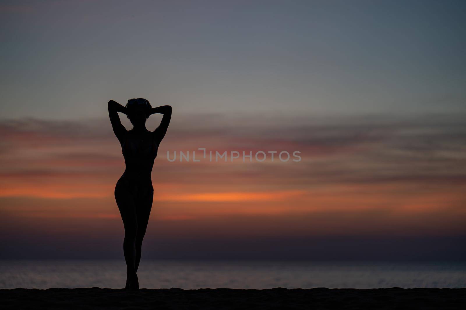 Silhouette portrait of woman wearing bikini on the beach, golden sunset moment. Holiday and travelling concept. by sirawit99