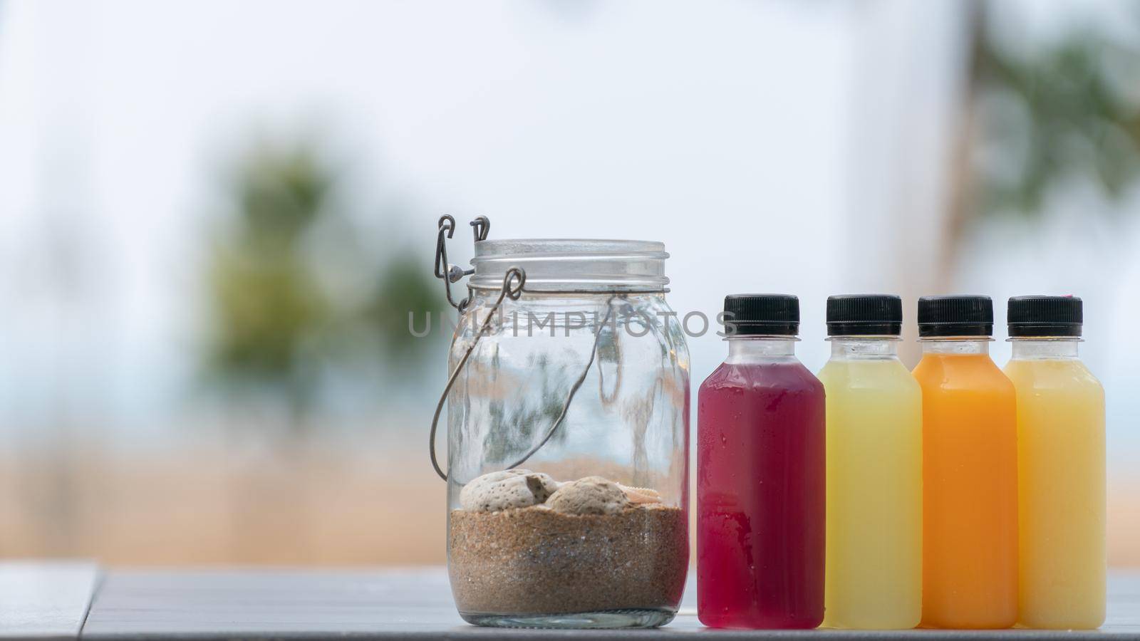 Healthy smoothies fruit and vegetable juice in bottles with sand in bottle