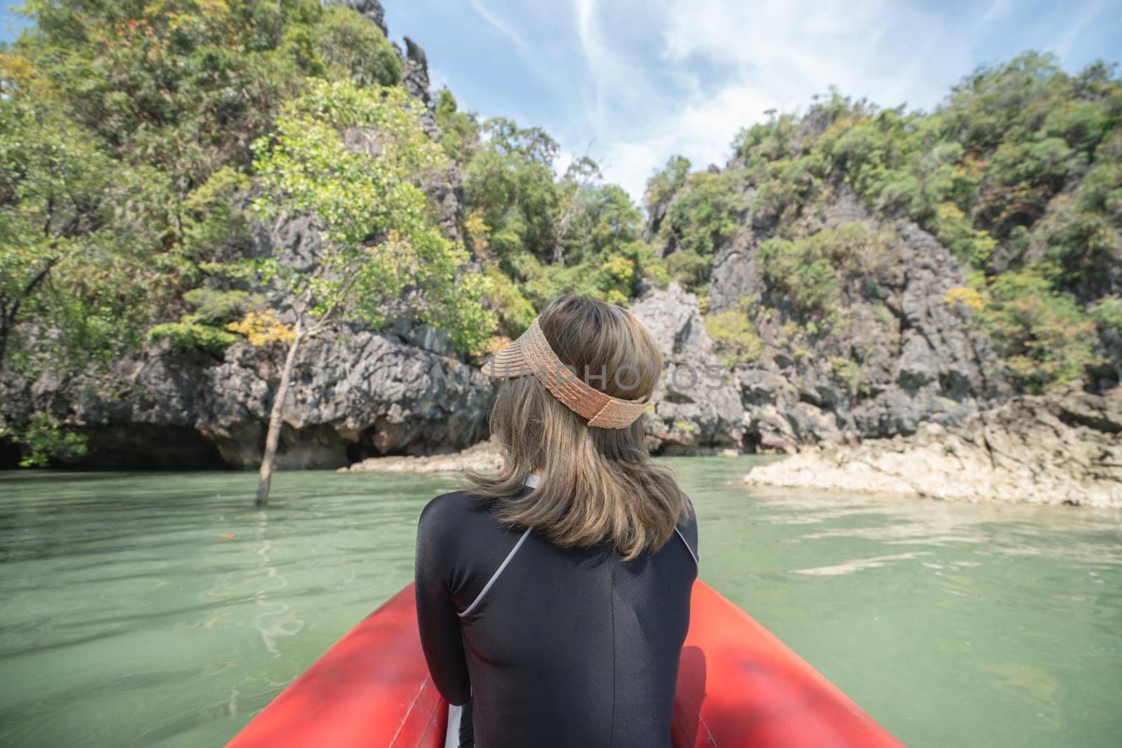 Back of woman tourist woman on a red kayak in Koh Hong, Tham Lot Cave at Hong Island in Phang-Nga Bay, Thailand. by sirawit99