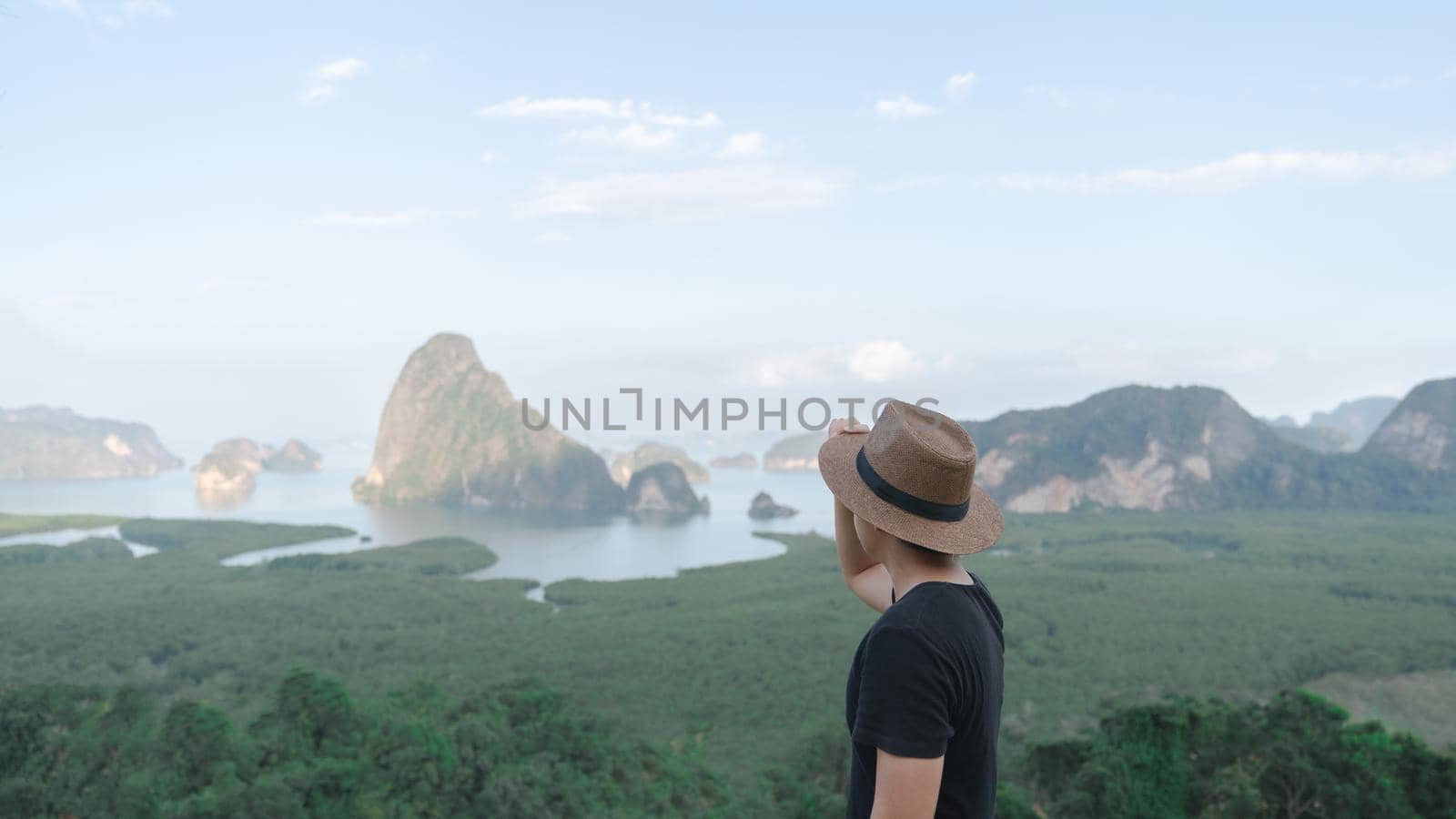 Samed Nang Chee. Man with view of the Phang Nga bay, mangrove tree forest and hills at Andaman sea, Thailand. by sirawit99