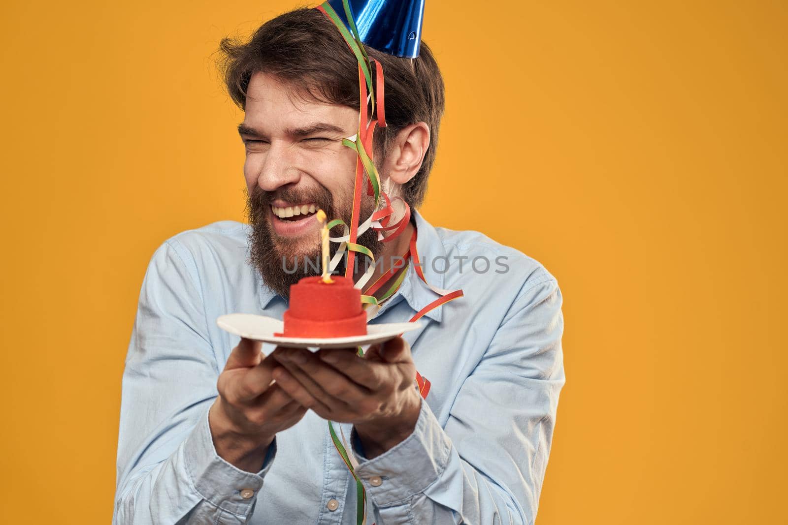 Birthday boy in a cap with a birthday cake in his hand and a candle by SHOTPRIME