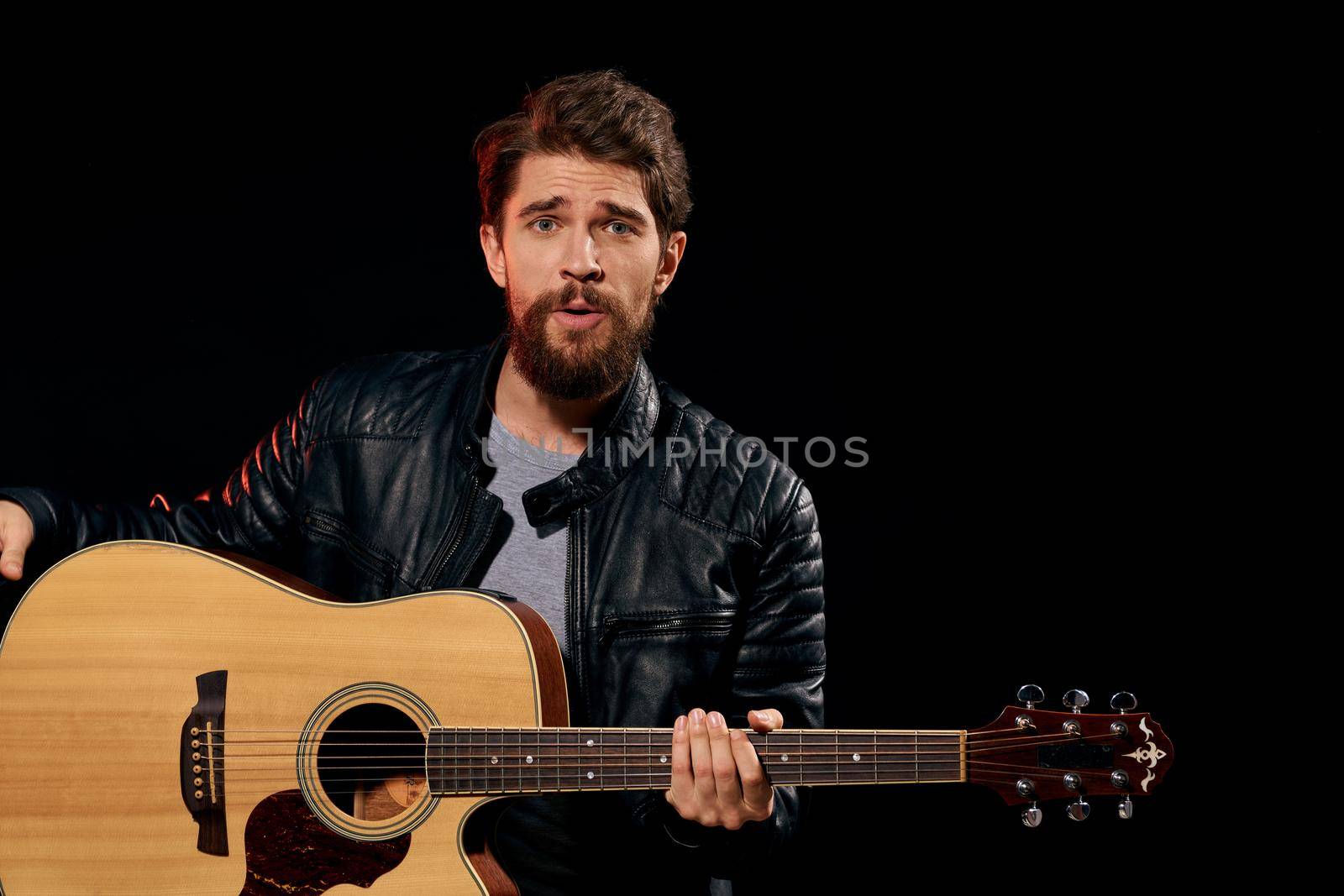 A man with a guitar in his hands leather jacket music performance rock star modern style dark background by SHOTPRIME